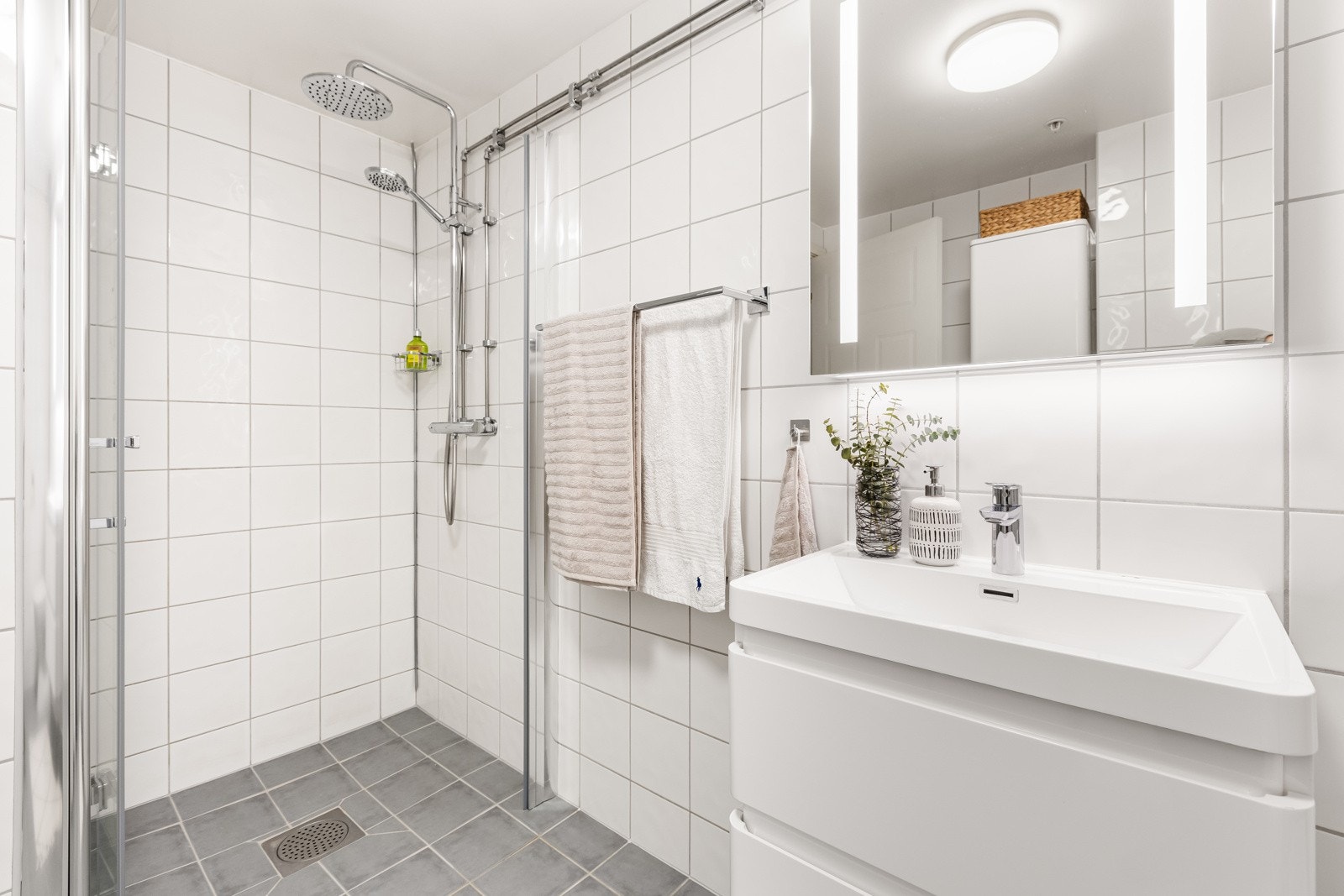 Videre har badet dusjhjørne med glassdør Galleribilde