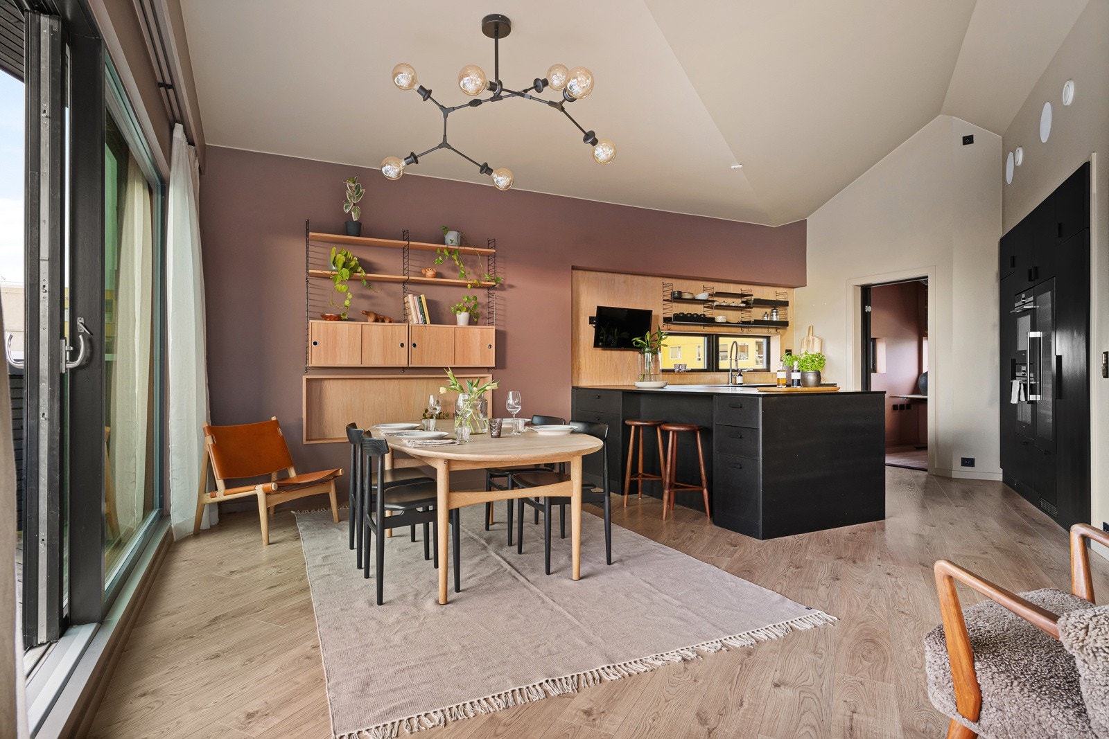 Stue og kjøkken med åpen løsning, noe som gir rommet en luftig og sosial atmosfære. Galleribilde