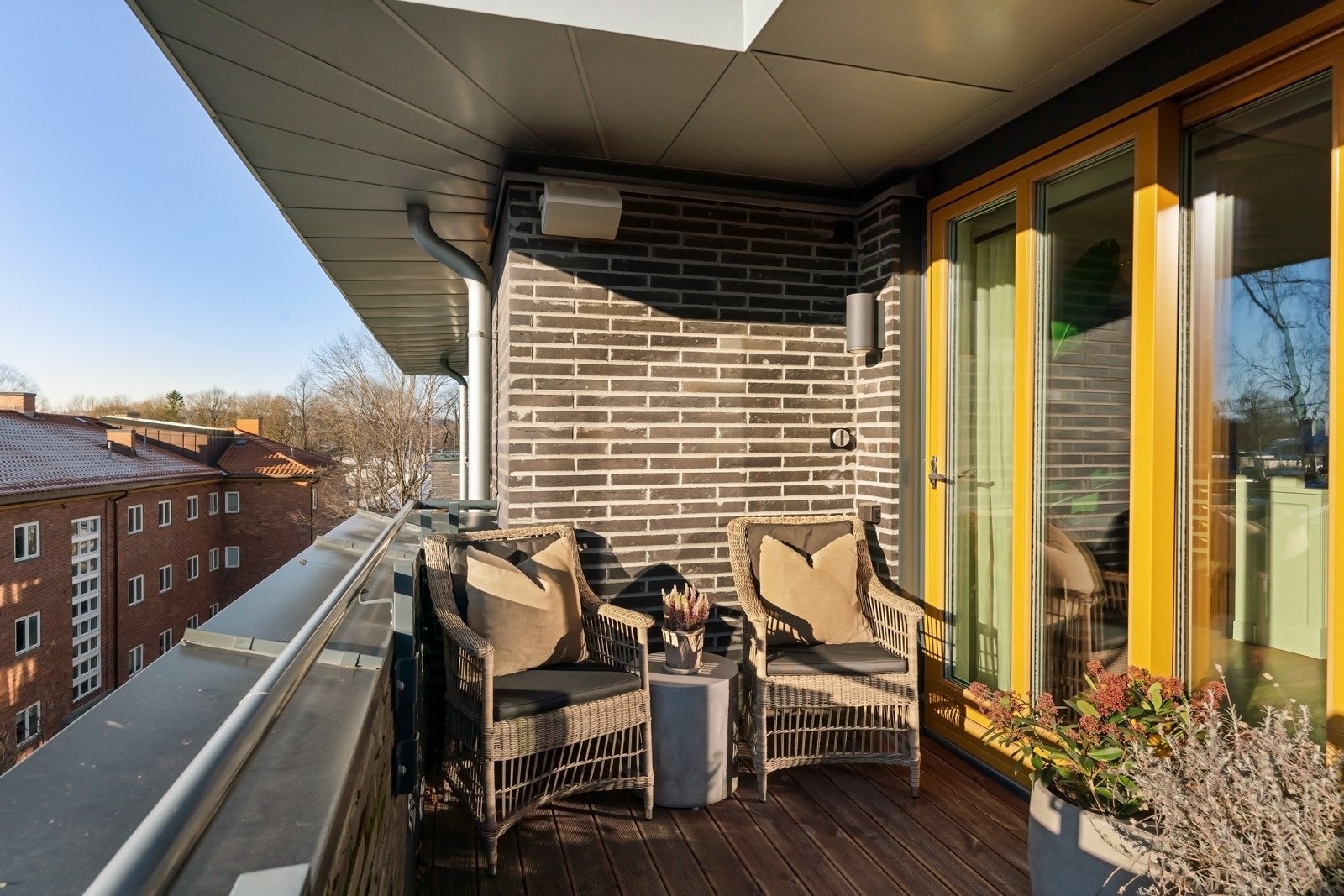 Uteplassen har dekke av terrassebord og god plass til møblering i flere soner, inkludert en loungegruppe i hjørnet utenfor stuen. Galleribilde