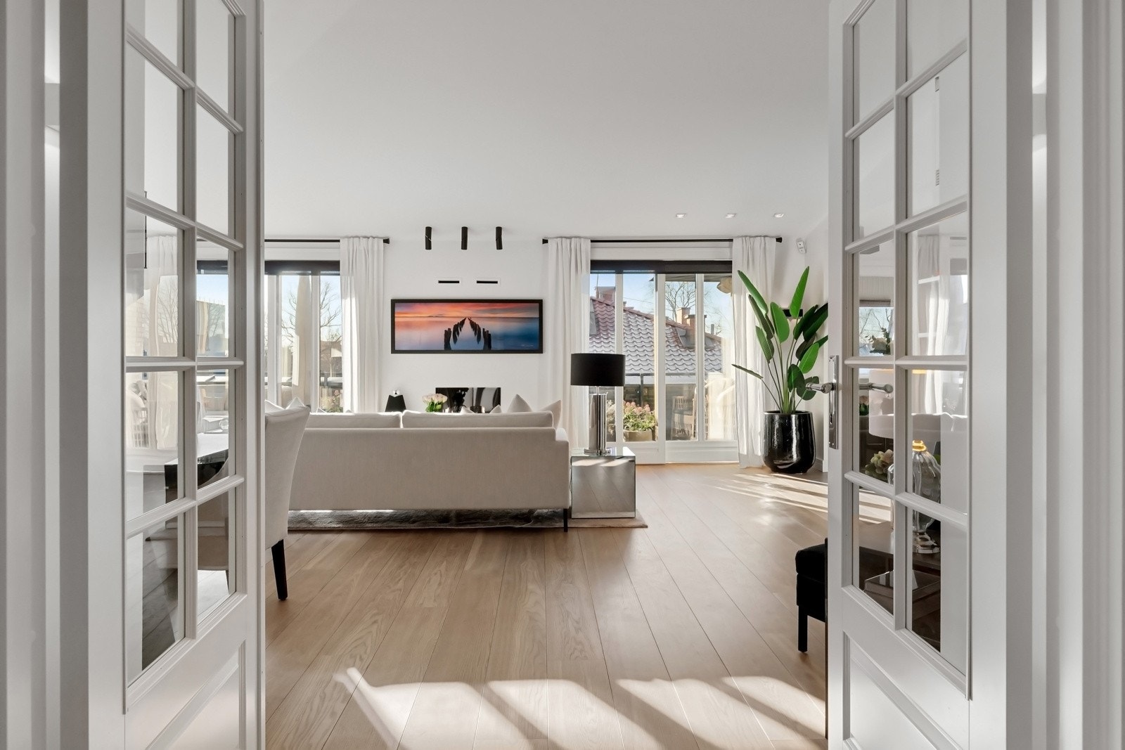 Fra hallen fører en tofløyet dør med glassfelt inn til stuen og en enkel, tilsvarende dør inn til mastersuiten. Galleribilde