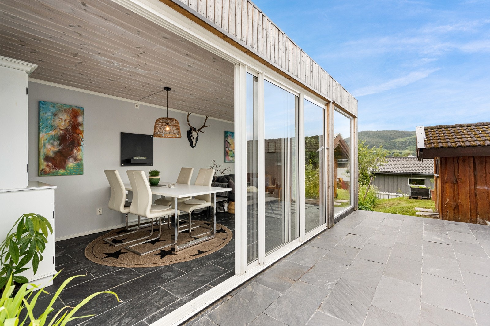 Hagestue på andre siden av boligen med fliser mellom Galleribilde