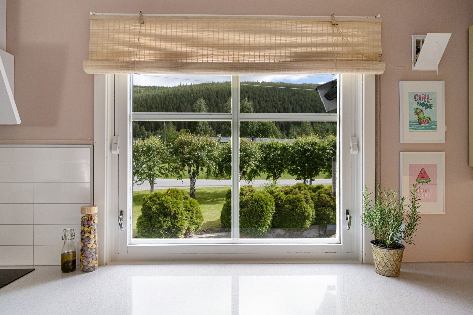 Utsikt til pent grøntareal i hagen fra kjøkkenvinduet Galleribilde