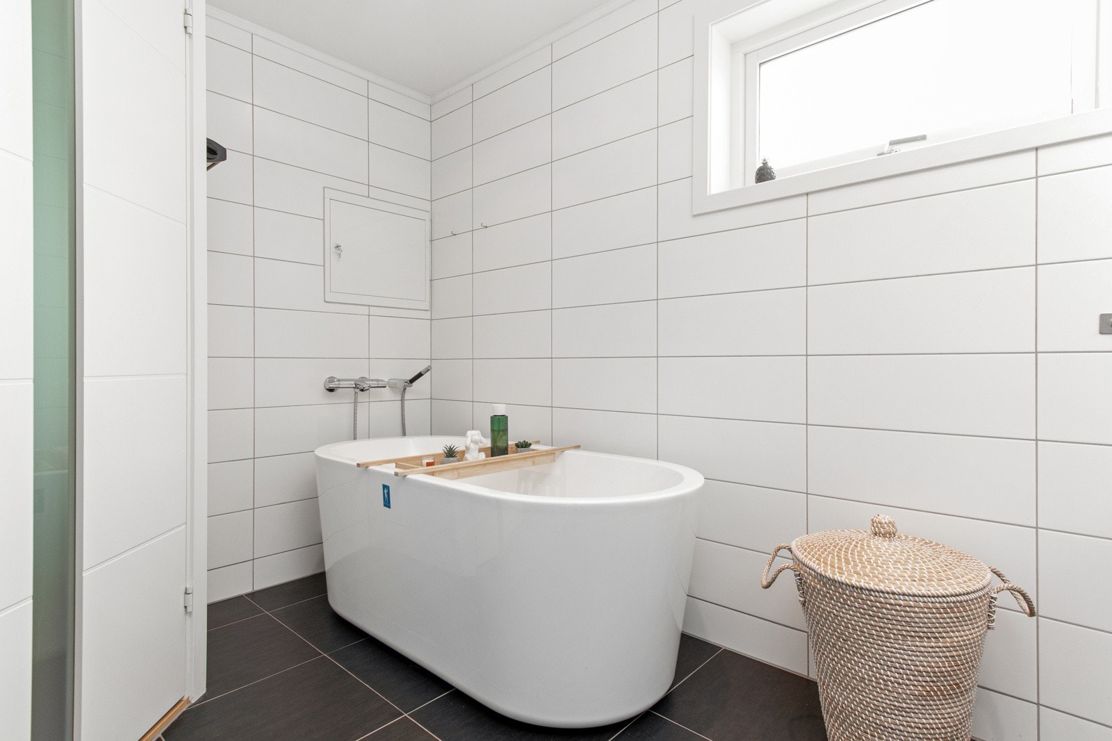 Badet har ellers mørke gulvfliser, lyse veggfliser, samt downlights, mekanisk avtrekk og varme i gulvet. Galleribilde