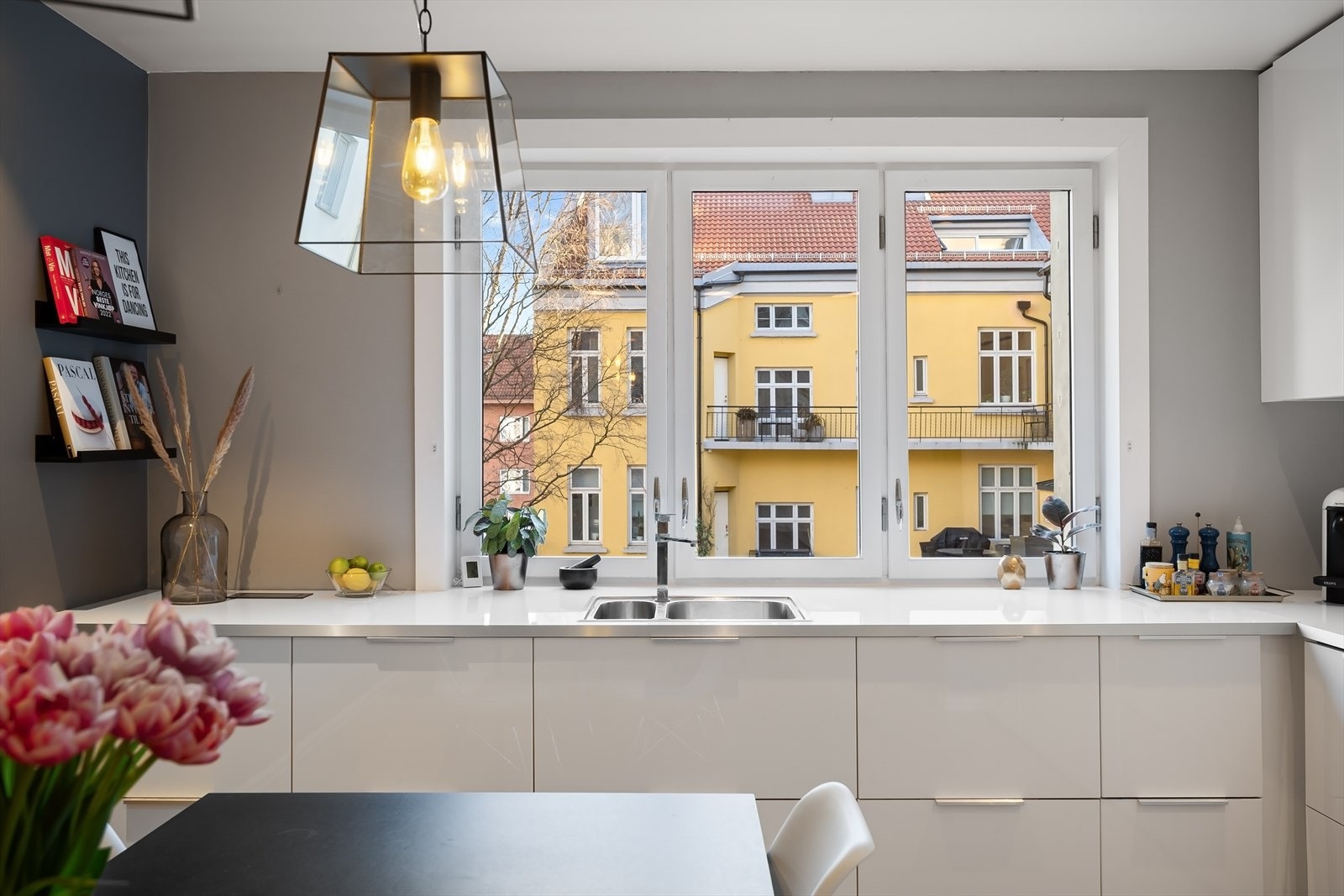 Stilren og moderne kjøkkeninnredning fra 2015 med hvite høyglans fronter og laminert benkeplate med nedfelt stålkum. Galleribilde