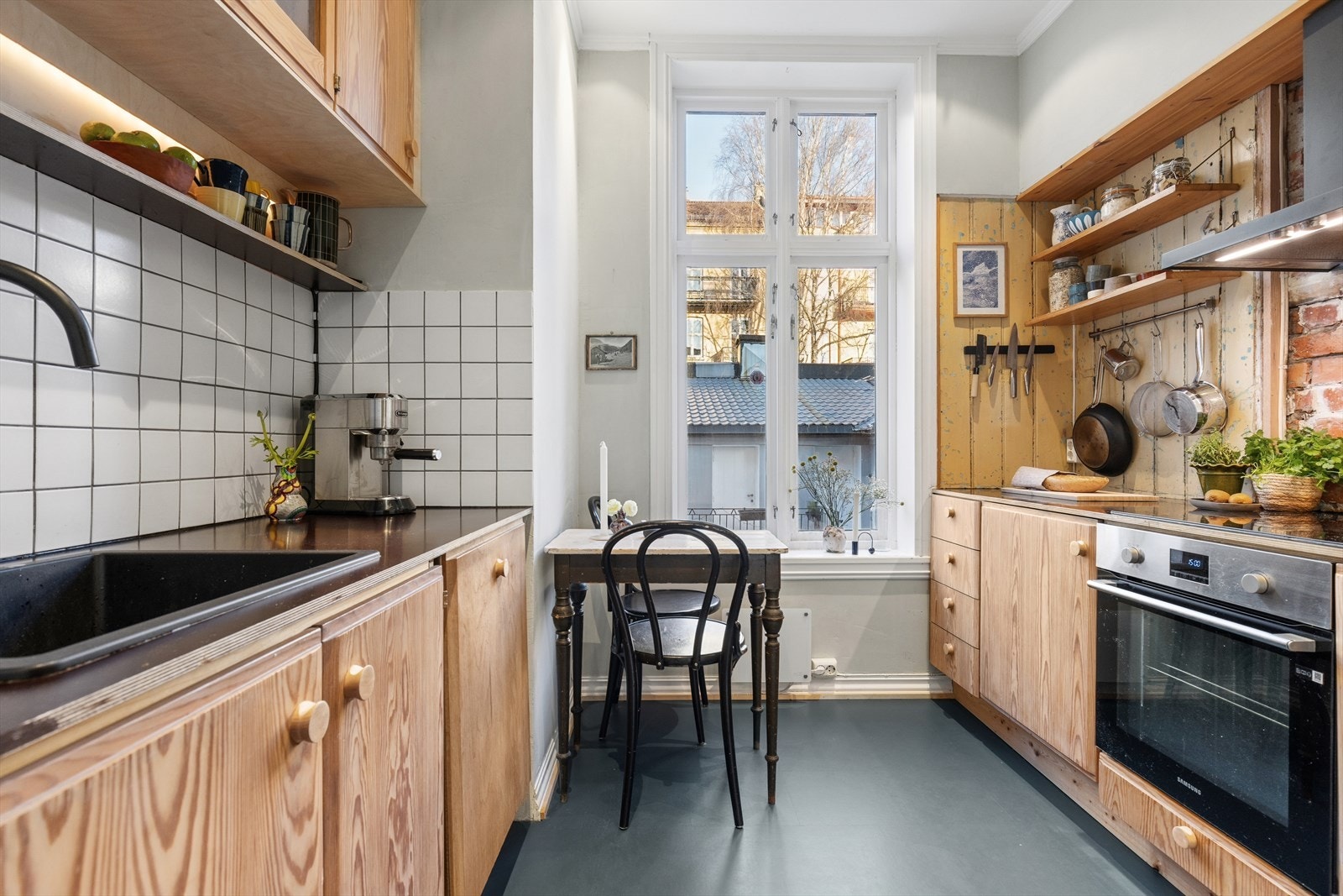 Kjøkkenet er en harmonisk blanding av gjenbruk, originale detaljer og nye elementer, hvor gamle materialer får nytt liv sammen med moderne løsninger for både funksjonalitet og sjarm. Galleribilde