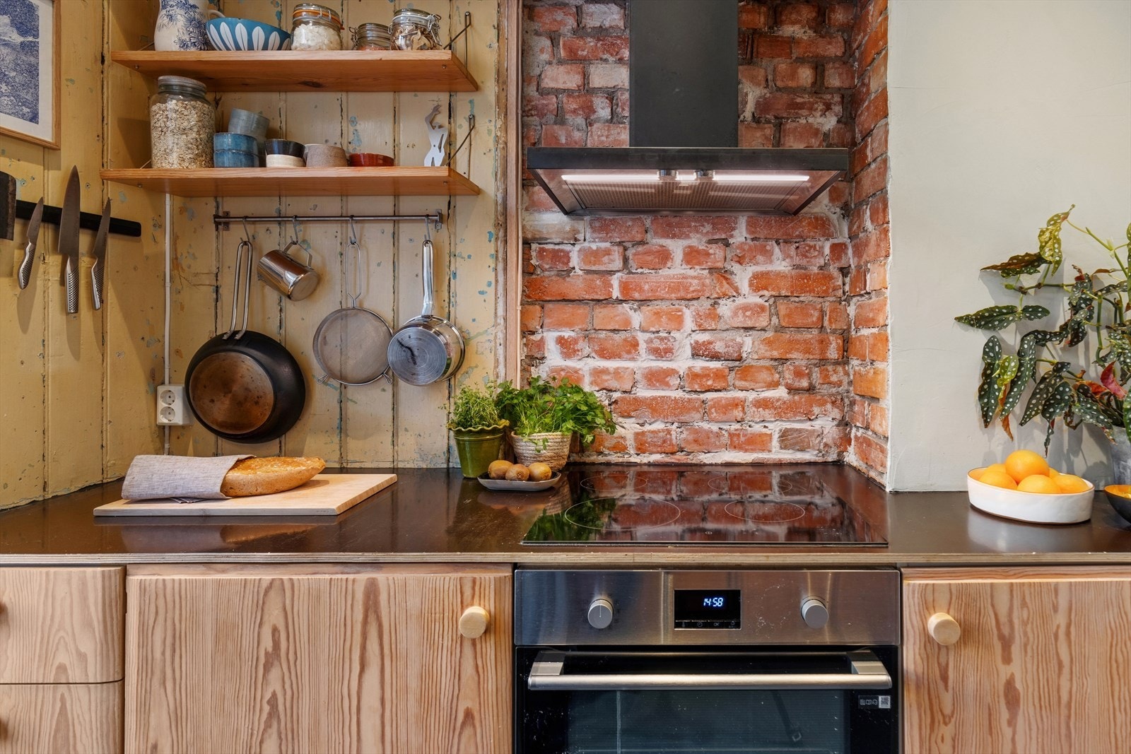 Original teglsten og panel har bevisst blitt bevart, og gir kjøkkenet et varmt og rustikt preg. Galleribilde