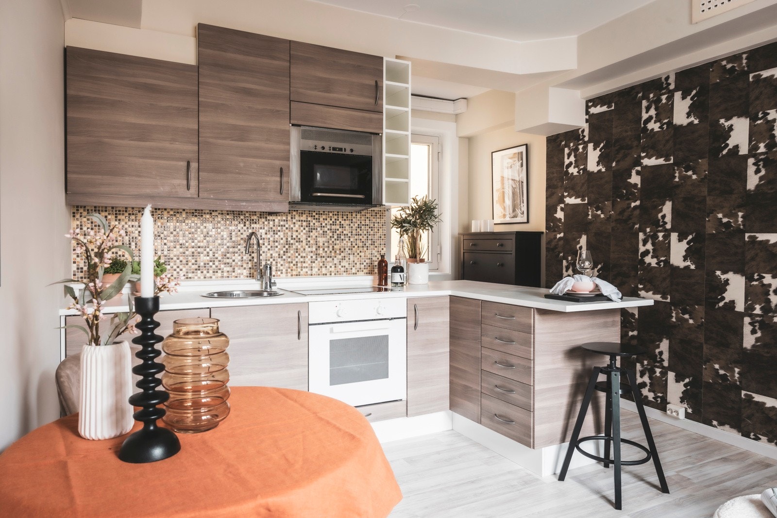 Leilighetens kjøkken har innredning bestående av glatte fronter, laminat benkeplate, og flislagt bakplate Galleribilde