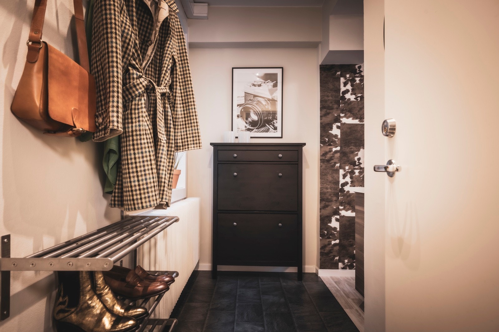 Man ankommer leiligheten i en innbydende entré med lyse flater og spotlights i taket Galleribilde