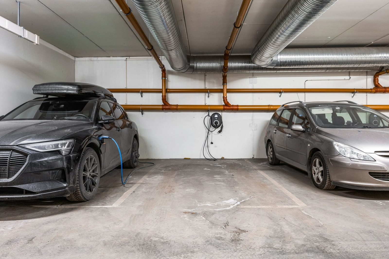 Parkeringsplass i garasje med ladestasjon for elbil. Galleribilde