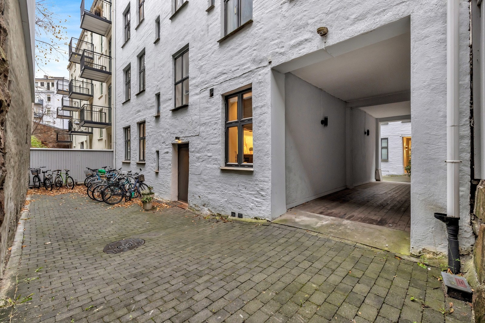 Gårdsrommet er opparbeidet med belegningsstein, sittegruppe, sykkelparkering og noe beplantning Galleribilde