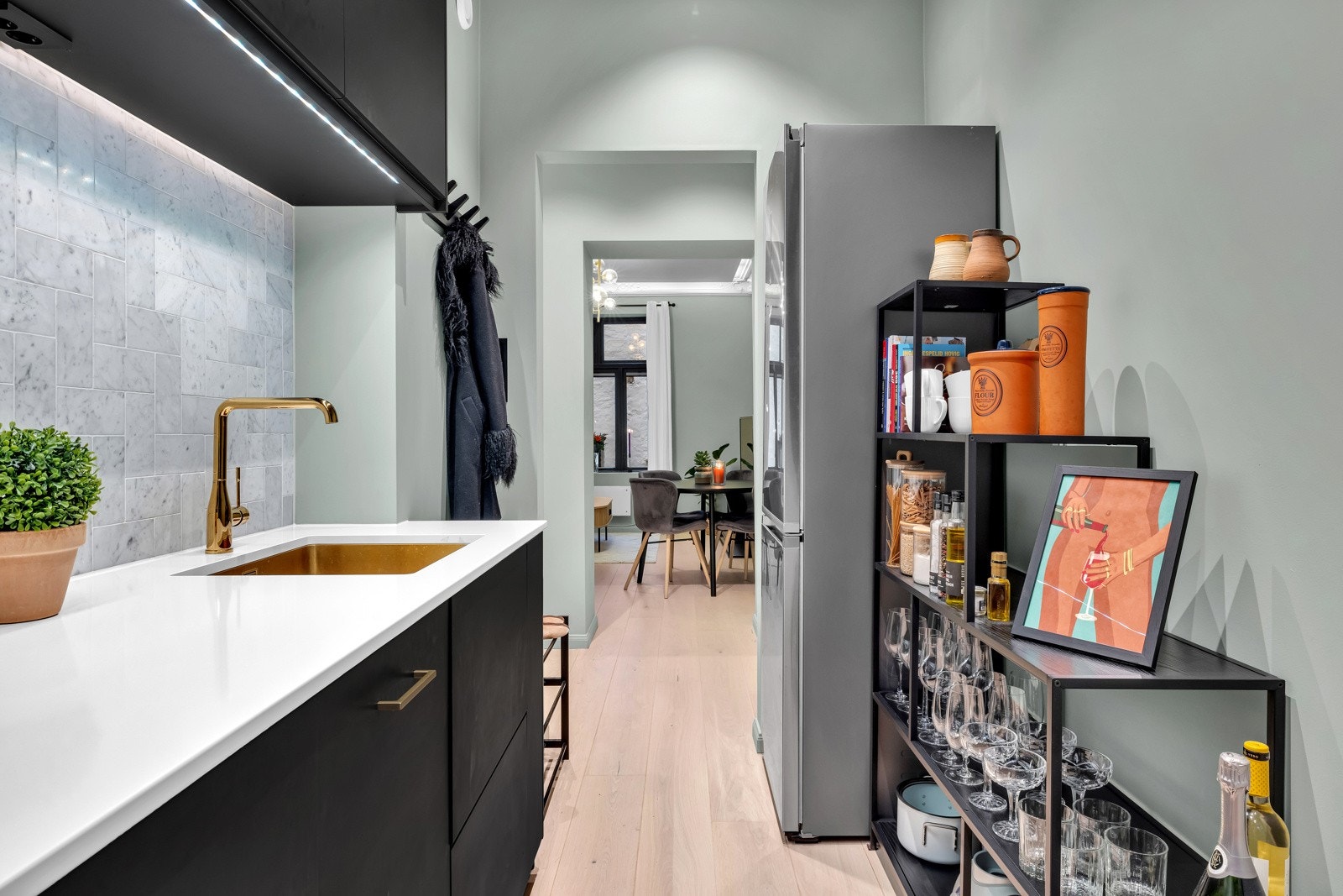 Innredningen fra Ikea har sorte, glatte fronter, "push to open" mekanisme og hvit benkeplate av kompositt med en oppvaskkum i rustfritt, kobberfarget stål Galleribilde