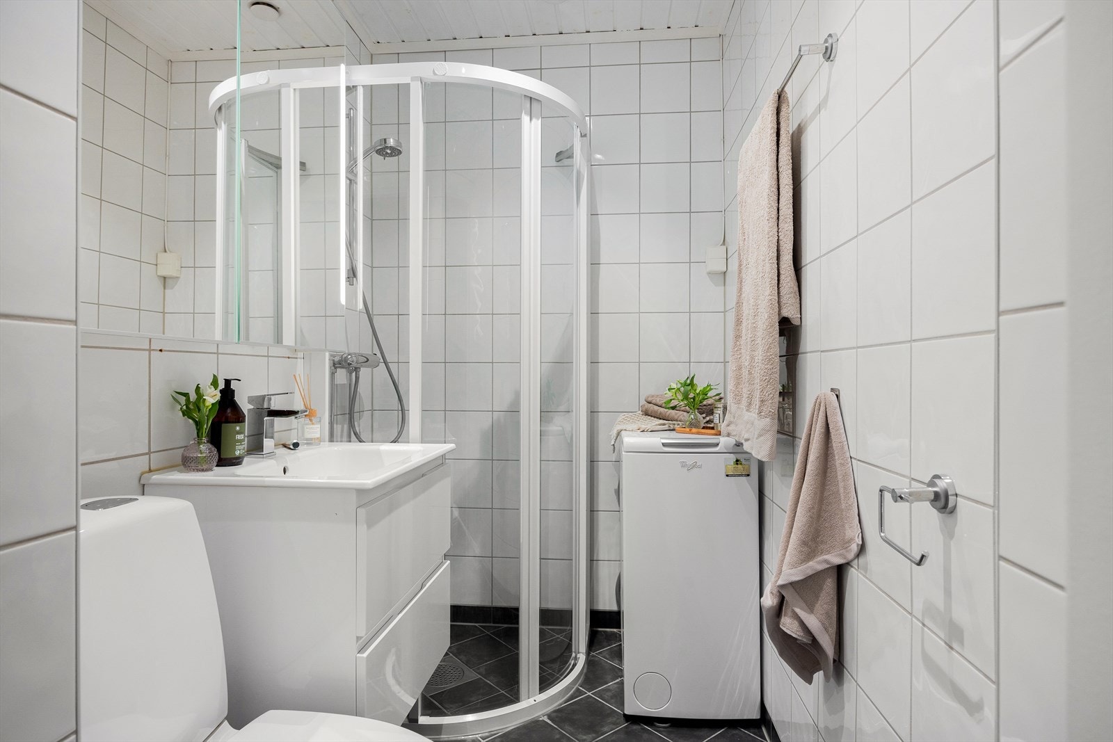 Badet er utstyrt med servantskap med høyglans fronter og heldekkende servant, samt speilskap med lysarmatur over servant. Galleribilde