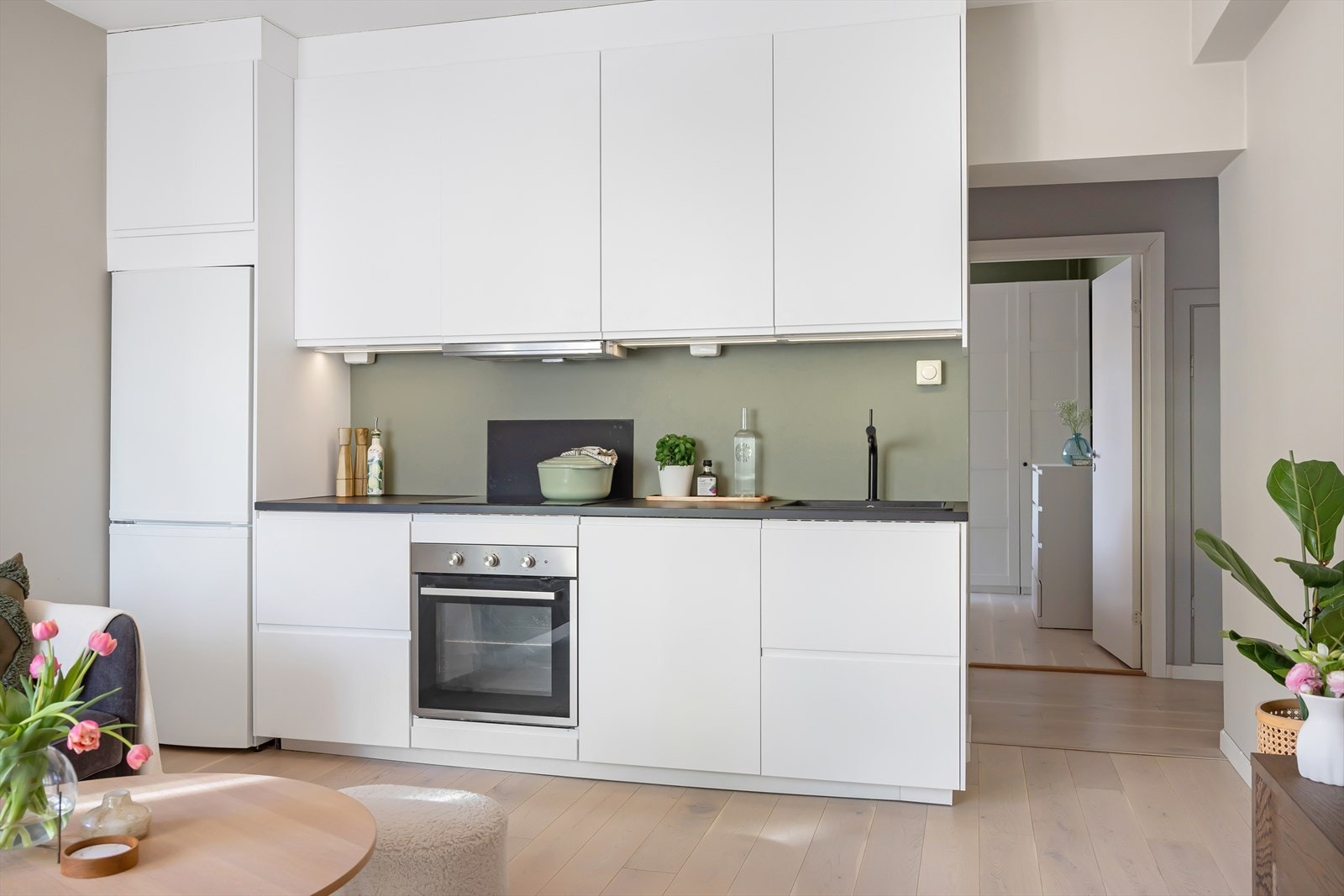 Moderne IKEA-kjøkken fra 2020 med rikelig skap- og benkeplass. Innredningen har glatte, folierte fronter, og benkeplaten er i laminat med nedfelt kum i kompositt. Galleribilde