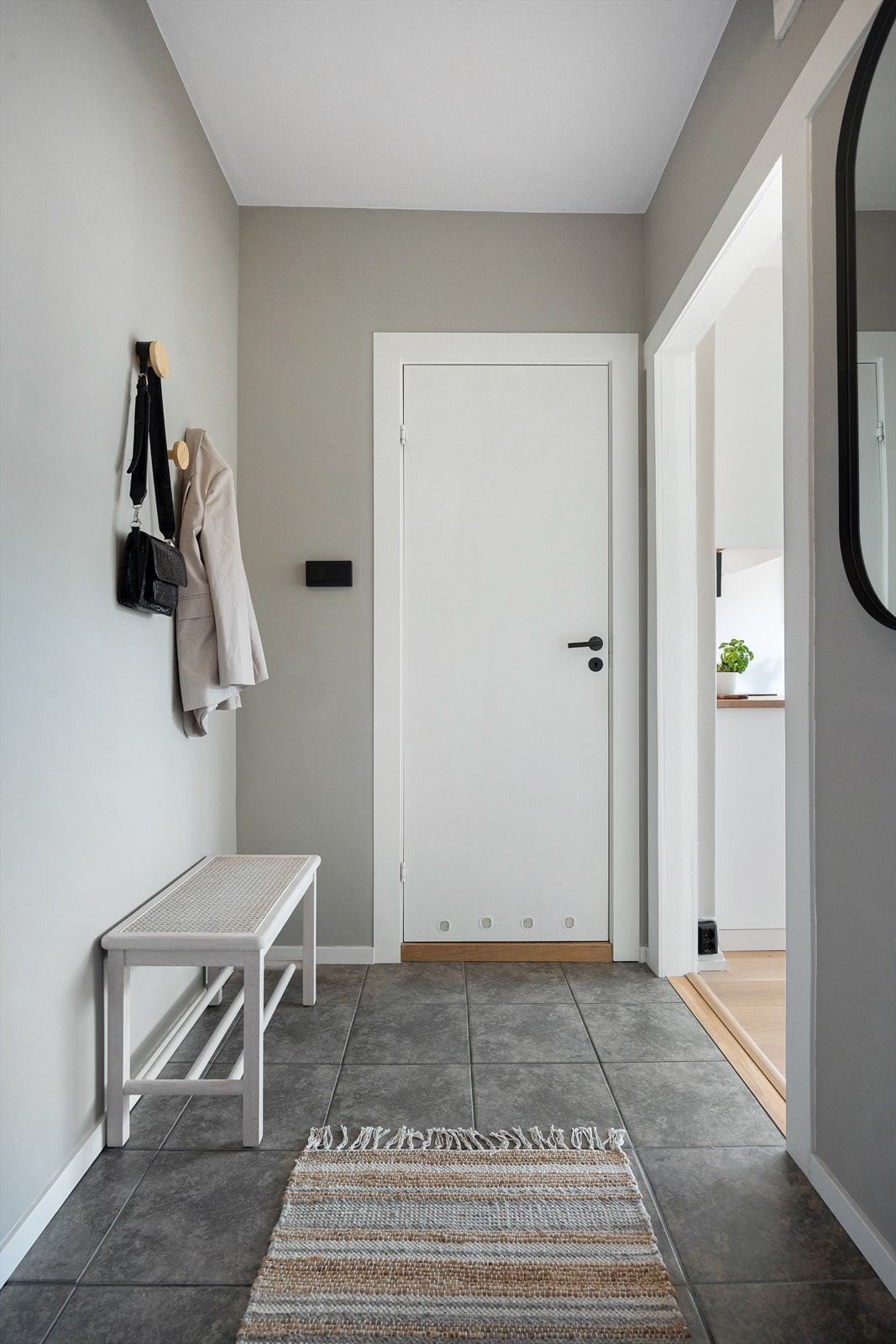 Velkommen inn! Leiligheten har en innbydende entré som skaper et umiddelbart godt førsteinntrykk. Her kan du enkelt henge i fra deg yttertøy på knaggrekke. Galleribilde