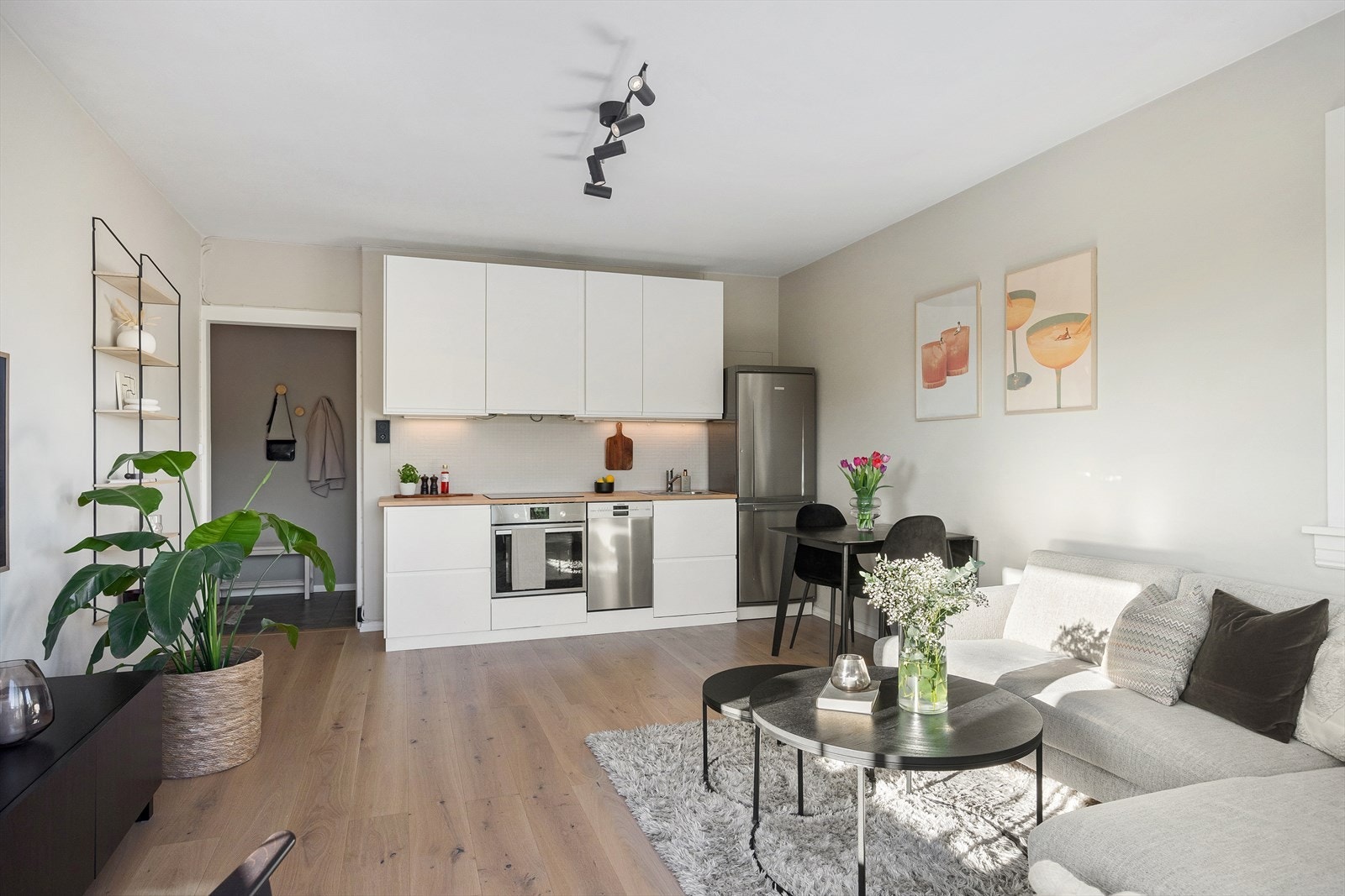 Moderne kjøkkeninnredning med glatte fronter med god skap og benkeplass. Benkeplaten er av heltre med en nedfelt vaskekum og belysning over benkeplaten. Galleribilde