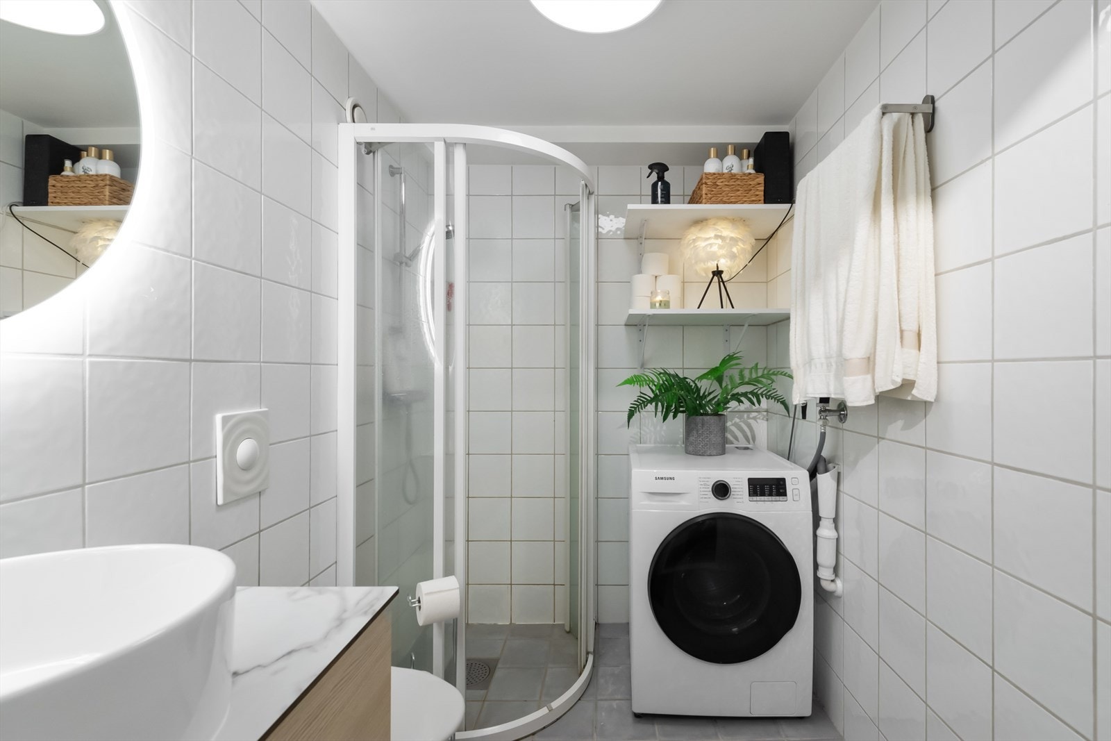 Leiligheten har et lekkert og fullverdig baderom med flislagt gulv og vegger. Rommet er innredet med en stor dusjone med dusjhjørne med skyvebare dører, lekker ny baderomsinnredning med bolleservant, vegghengt toalett og belyst speil. Galleribilde