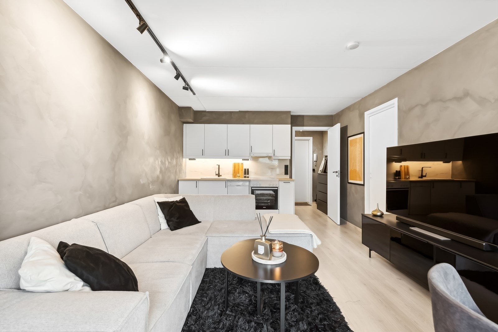 Stuen er pent gjennomført med et øye for detaljer med hensyn til farge- og materialvalg. Det er i tillegg montert god belysning med lekre spotskinner i taket som gir fin belysning. Galleribilde