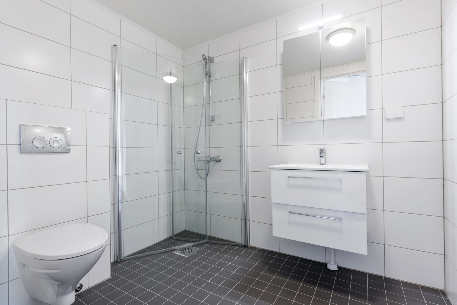 Lyst og romslig baderom med opplegg for vaskemaskin. Galleribilde