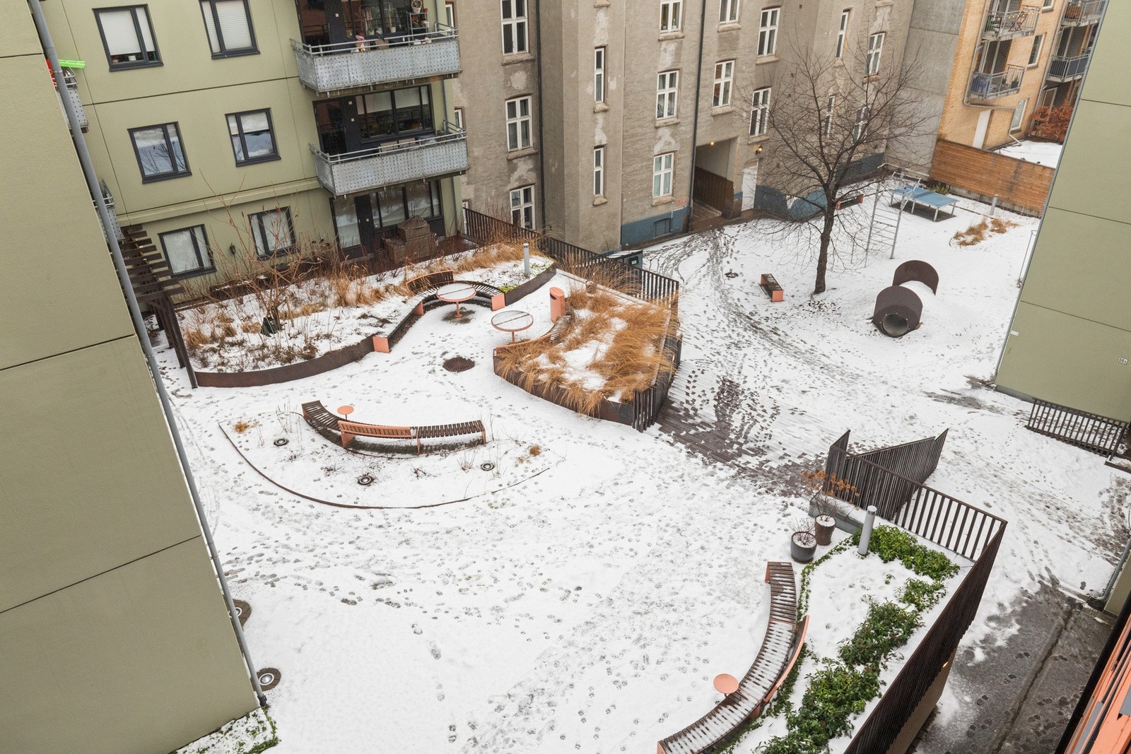 Sameiets bygninger ligger samlet rundt en herlig bakgård som ble totalrenovert i 2022 og vokser seg frodig og grønn sommerstid Galleribilde