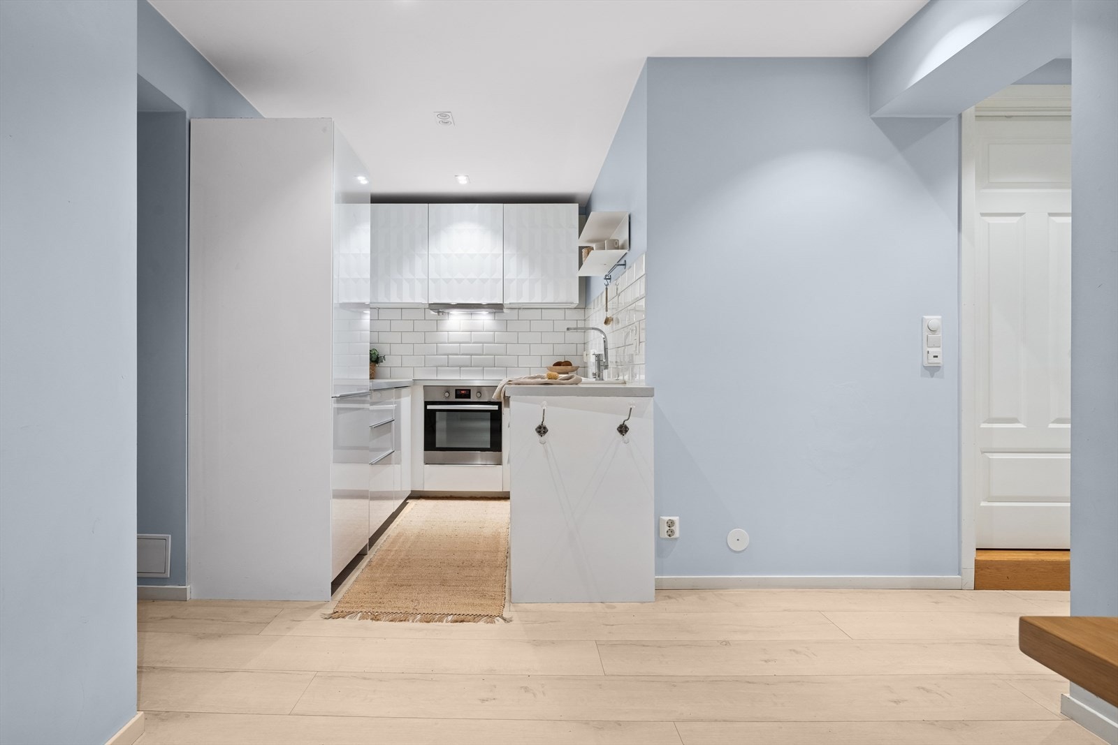 Kjøkkenet ligger i en sosial løsning mot leilighetens spisestue. Kjøkkenet har Ikea kjøkkeninnredning fra 2015 med mønstret skapfronter i overskap. Øvrig kjøkkeninnredning har glatte fronter i hvit høyglans. Galleribilde