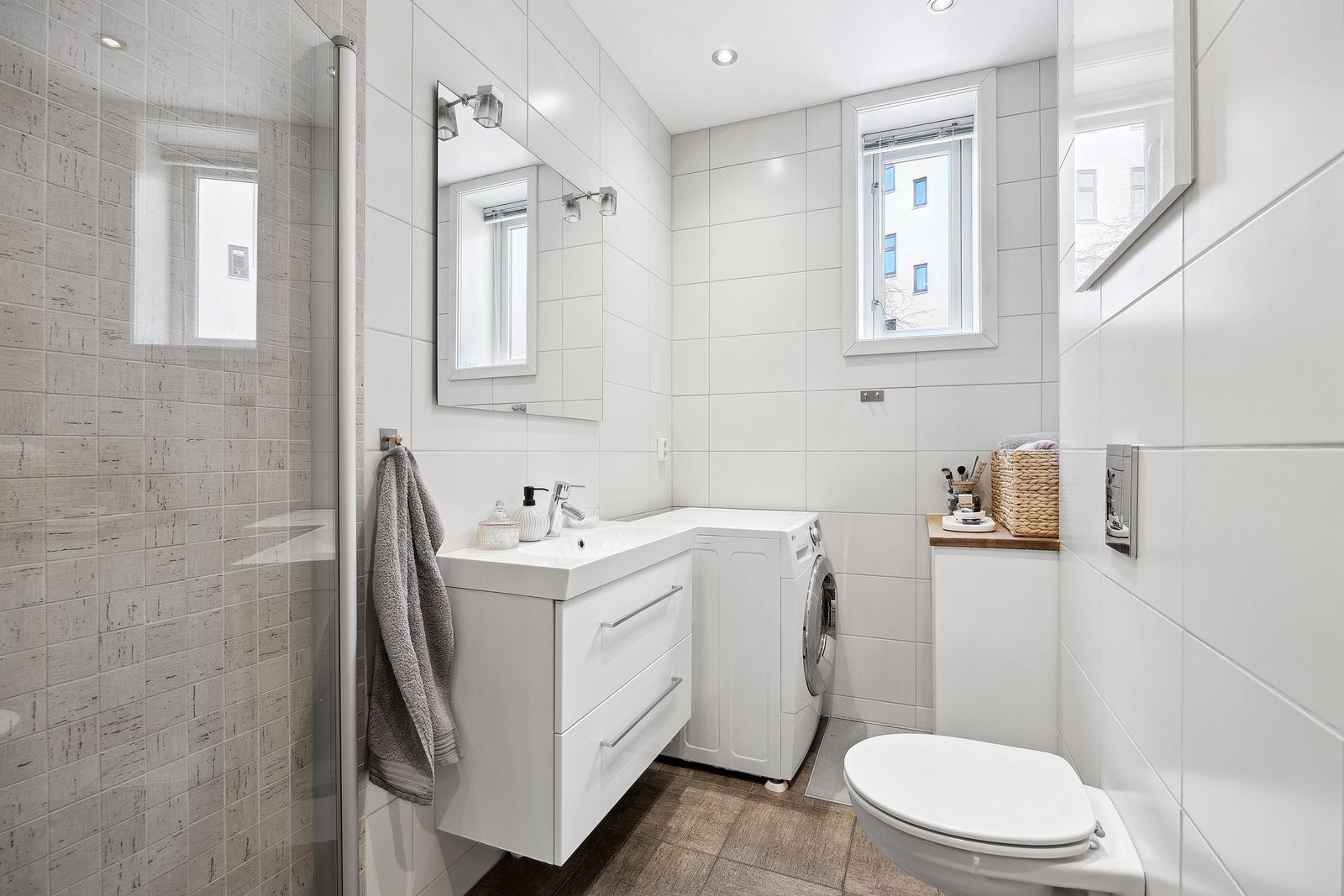 Flott flislagt bad med gulvvarme, innfellbare dusjdører og vaskemaskin. Galleribilde