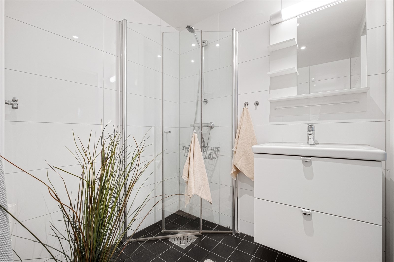 Pent, flislagt baderom med varmekabler, avtrekk, speil, armatur, downlights, opplegg for vaskemaskin, servant med innredning, dusj hjørne med innfellbare glassdører, vegghengt toalett. Galleribilde