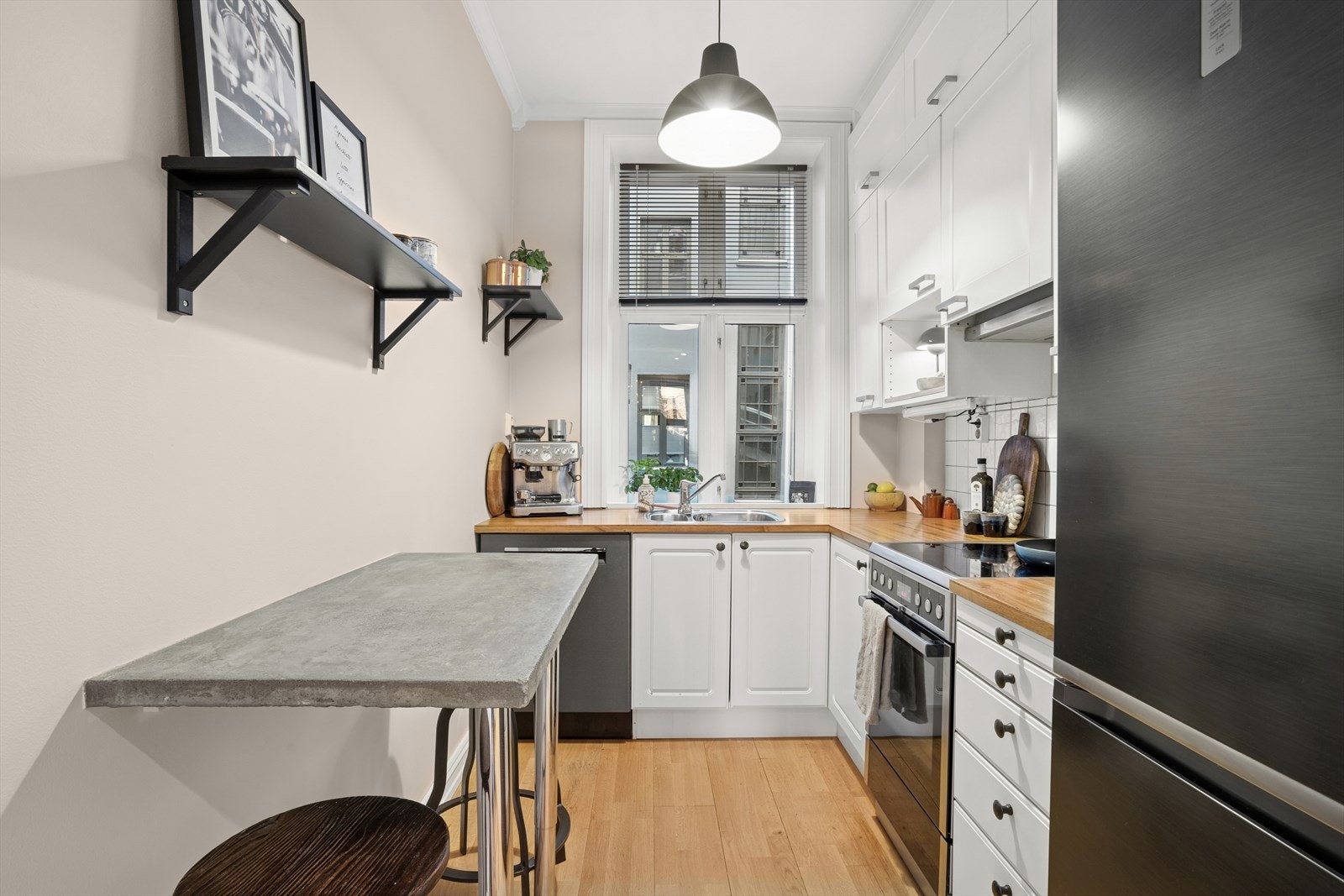 Stilren kjøkkeninnredning med god skap- og benkeplass. Ventilator og frittstående hvitevarer som komfyr, oppvaskmaskin, kjøl/- fryseskap. Galleribilde