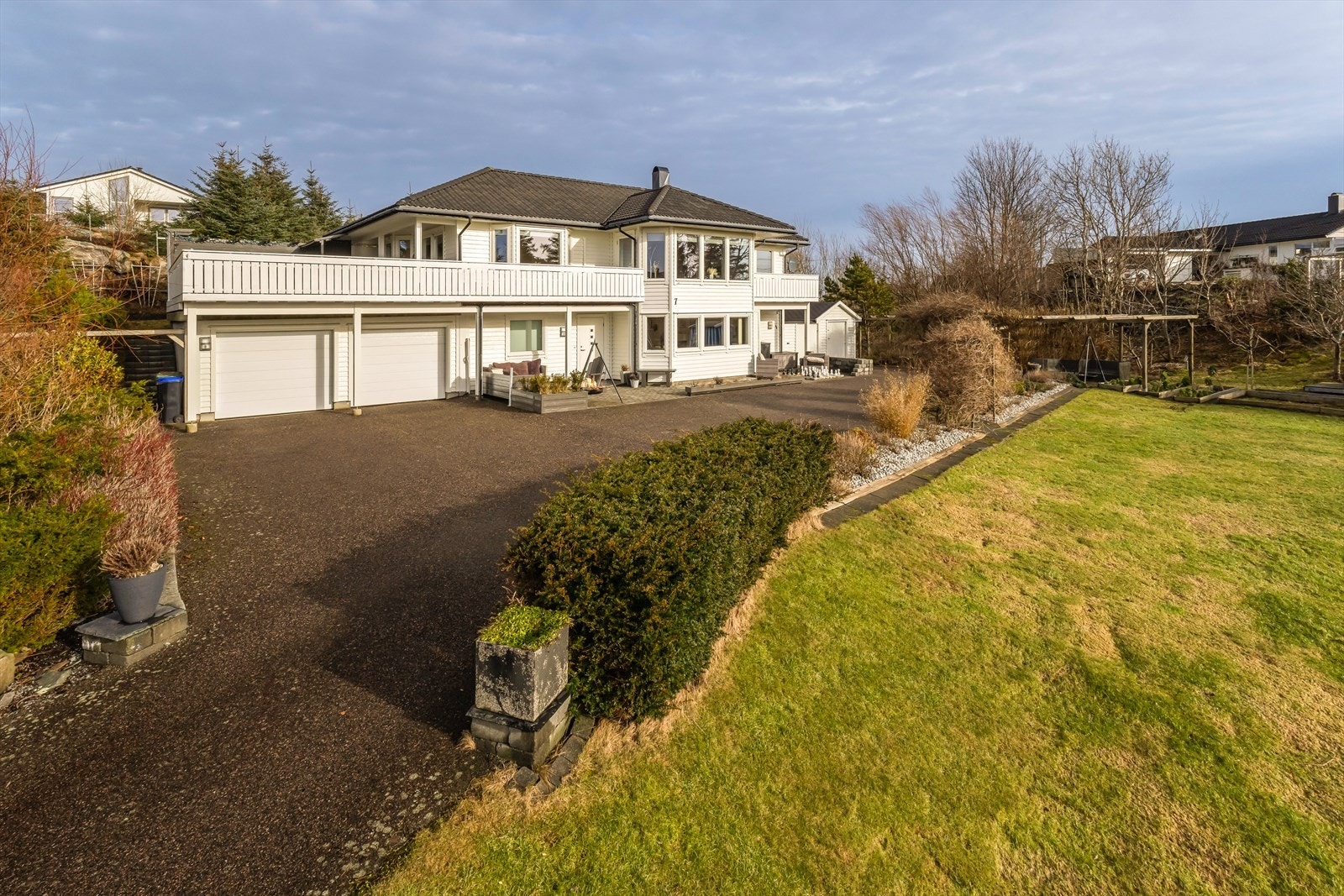 Asfaltert innkjørsel med flere biloppstillingsplasser Galleribilde