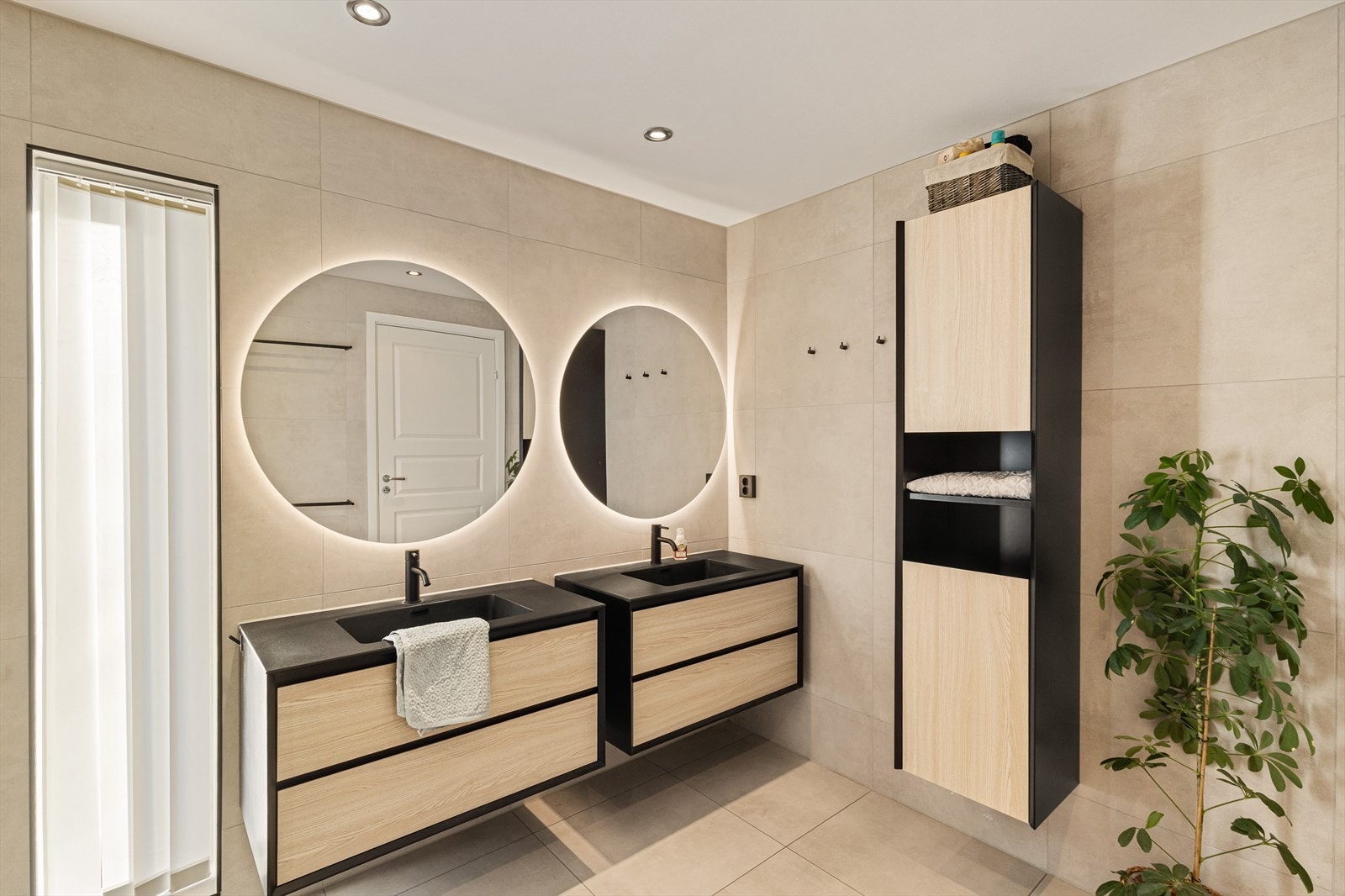 Badet er utstyrt med vegghengt toalett, dusj og baderomsmøblement med to servanter og speil med belysning. Galleribilde