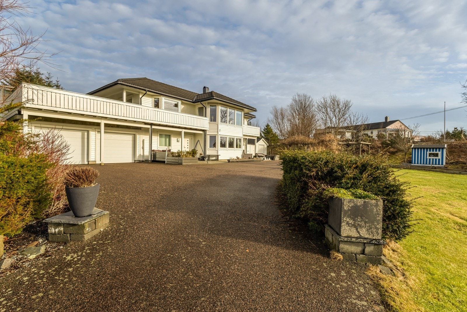 Eiendommen har en dobbeltgarasje med to porter. Fra garasjen kan man gå tørrskodd inn i eiendommen til stor, praktisk bod. Galleribilde
