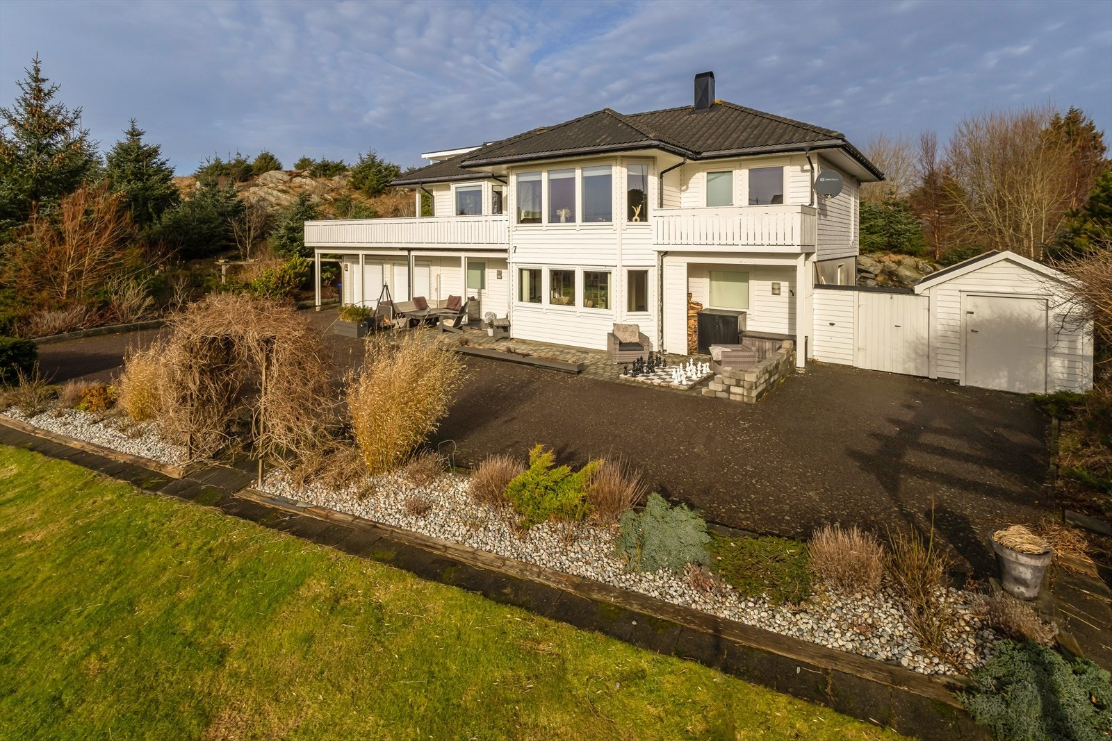 Rundt eiendommen finner man flere fine uteområder, med blant annet gressplen, terrasse og romslig altan Galleribilde