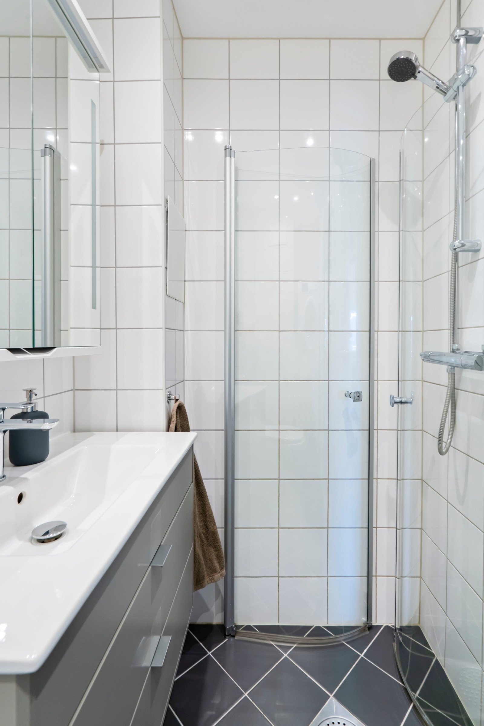 Badet er utstyrt med vegghengt toalett, dusjhjørne og servant med ettgreps blandebatteri. Galleribilde