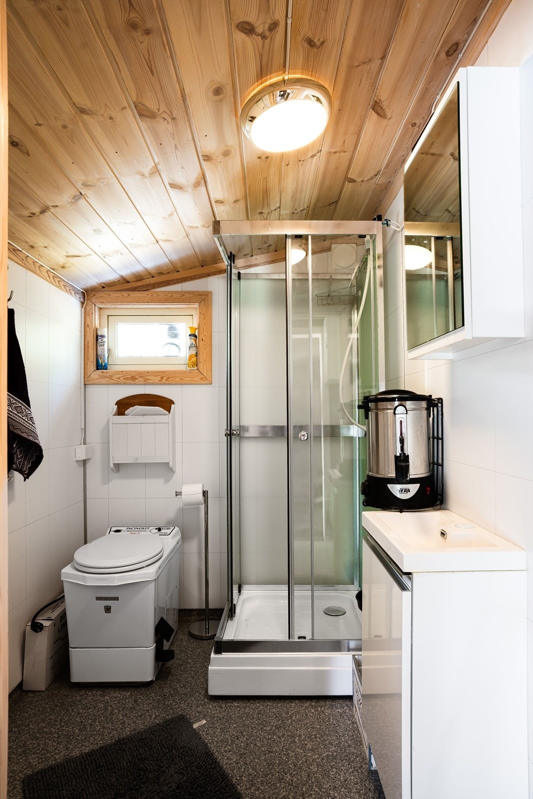 Hygienerom oppusset i ca. 2021 med belegg på gulv og baderomsplater på veggene. Rommet er utstyrt med baderomsinnredning, speilskap, dusjkabinett og forbrenningstoalett. Galleribilde