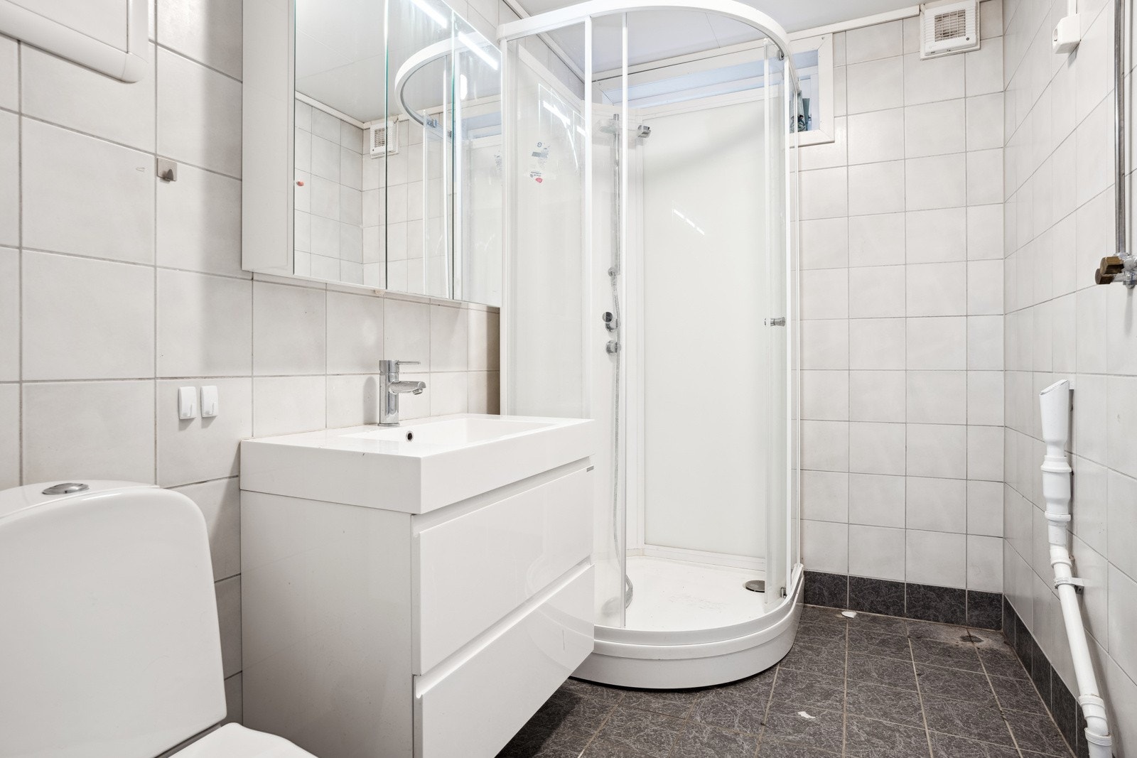 Badet har dusjkabinett og innredning med servant. Galleribilde