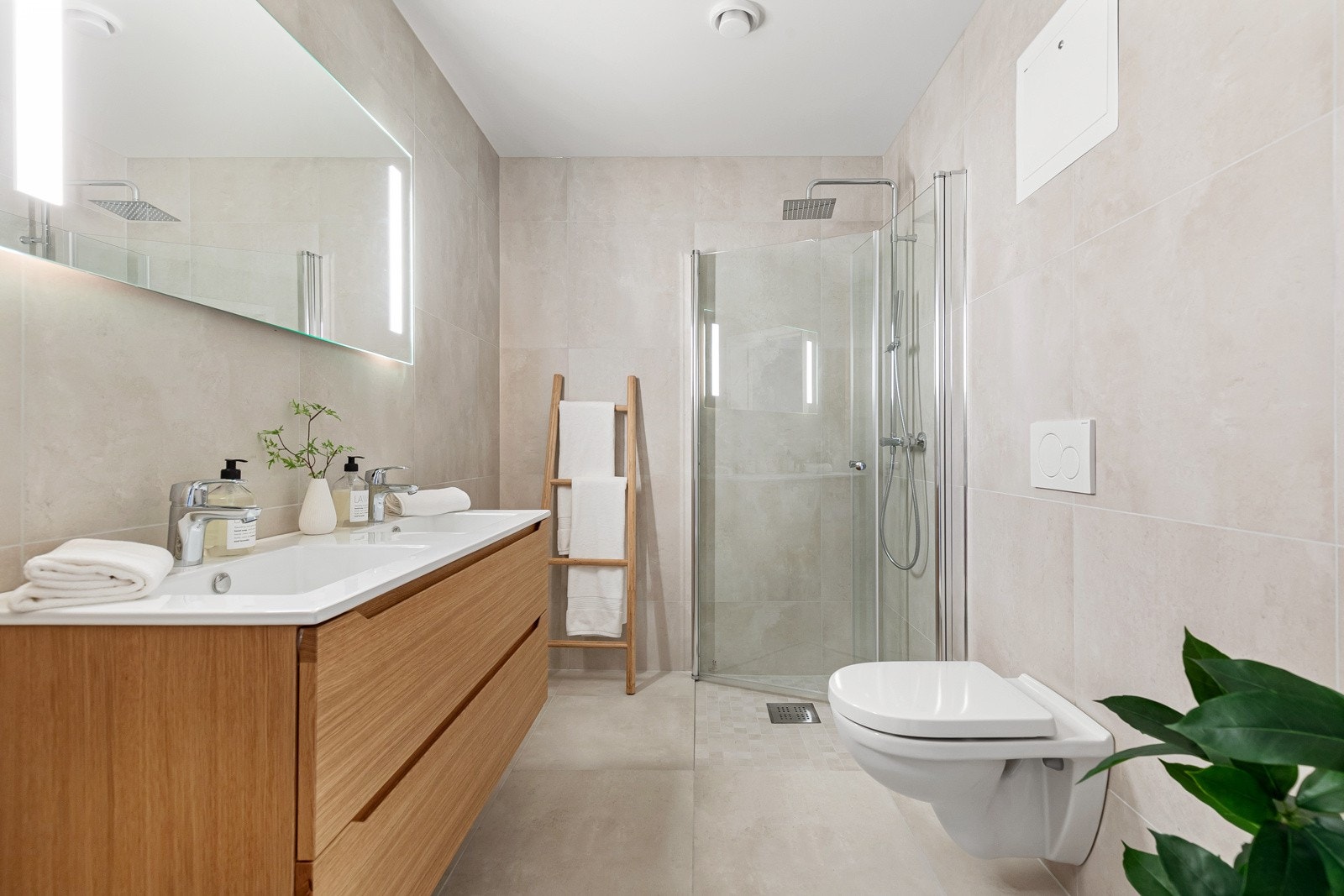 Stort bad med to nedfelte servanter, skuffeløsning og dusjhjørne. Galleribilde