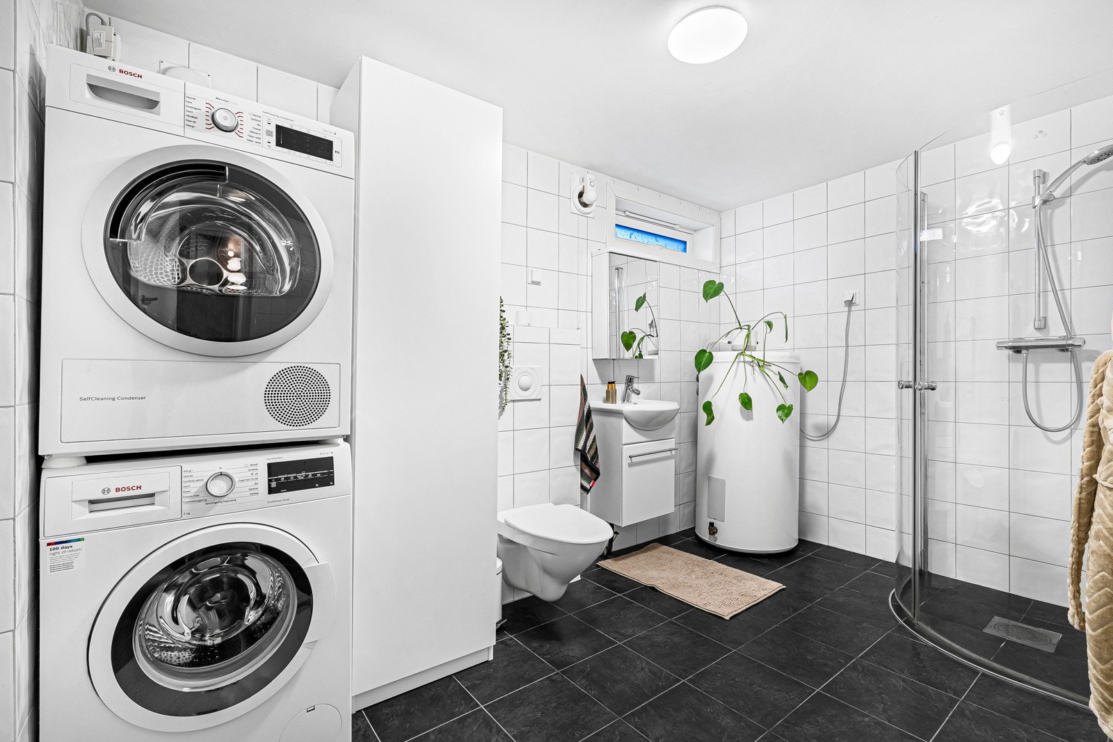 Badet i kjelleren er pent innredet med fliser på gulv og vegg. Det er også opplegg til vaskemaskin. Galleribilde