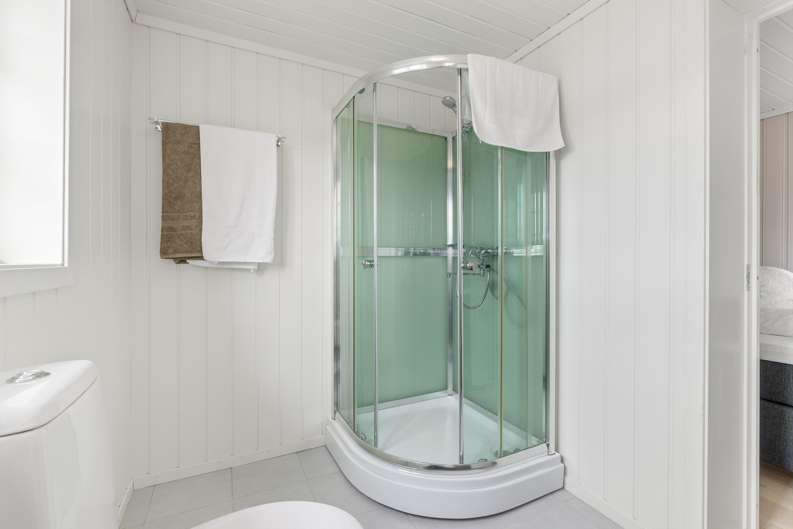 Baderom (renovert 2010) har flis på gulv og gulvvarme, vegger har mdf plater og tak har malt panel. Innredet med kabinett,
innredning m/servant, klosett, benk og hylle. Galleribilde