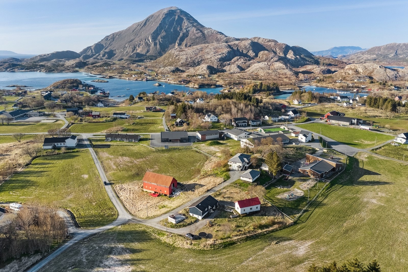 Oversiktsbilde av beliggenheten. Det er gangavstand til sjøtomten fra boligene og låve/fjøs. Galleribilde