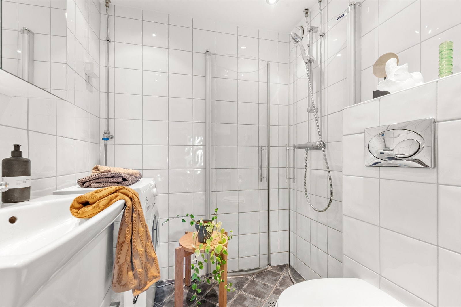 Badet er pent flislagt på gulv og vegger med varme i gulvet. Innredningen består av vegghengt servantskap med heldekkende servant. Galleribilde