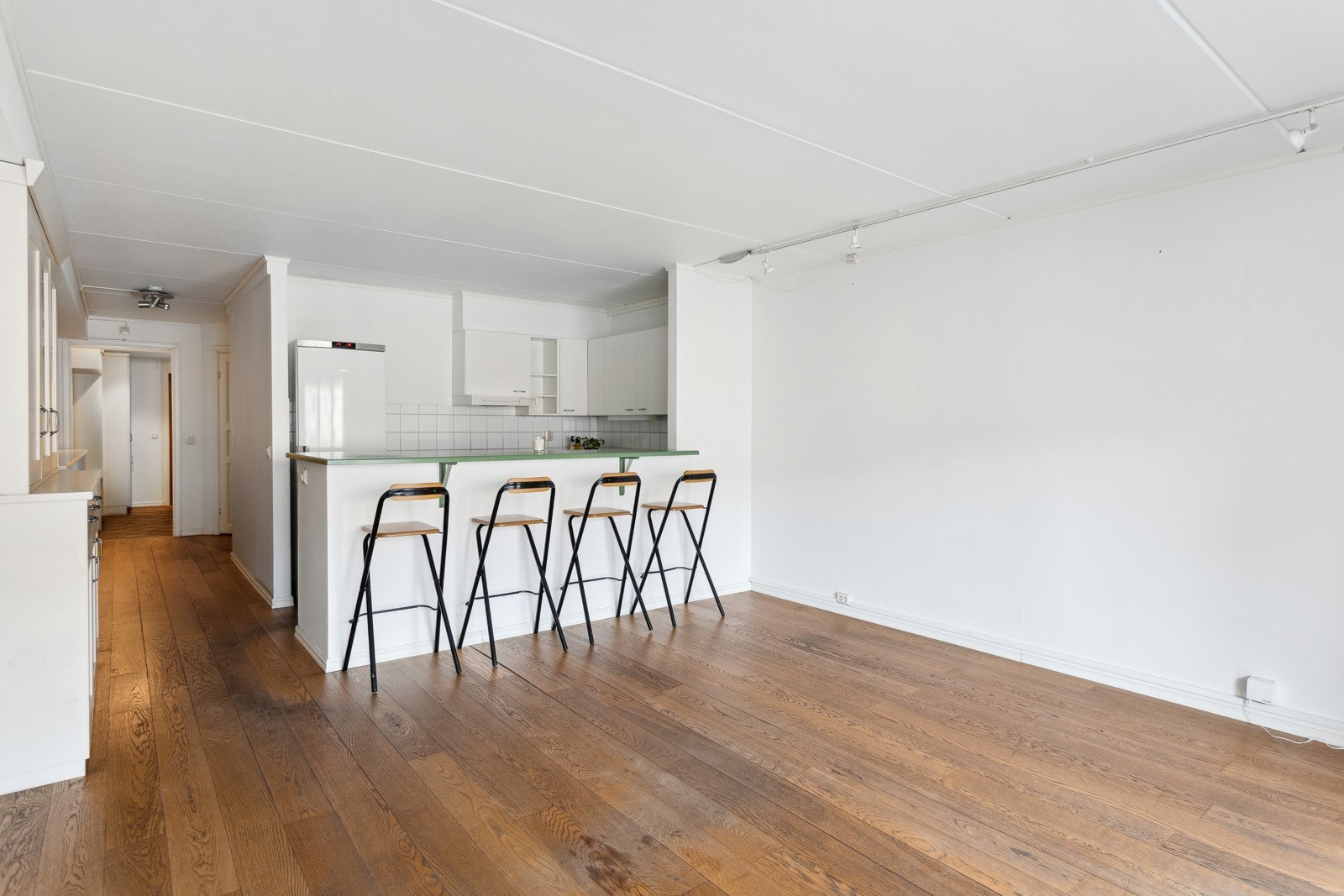 Stue og kjøkken i åpen løsning, med 1-stavs eikeparkett på gulv. Galleribilde