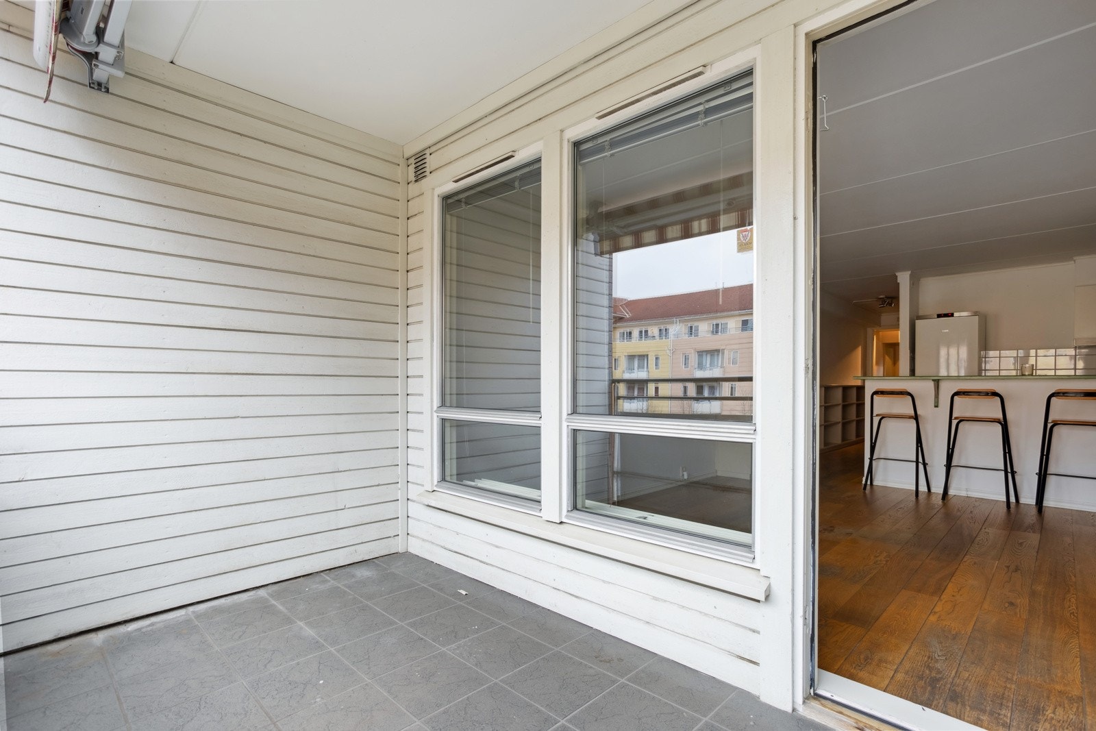 Balkongen er belagt med fliser på gulv, utebelysning og markise. Galleribilde