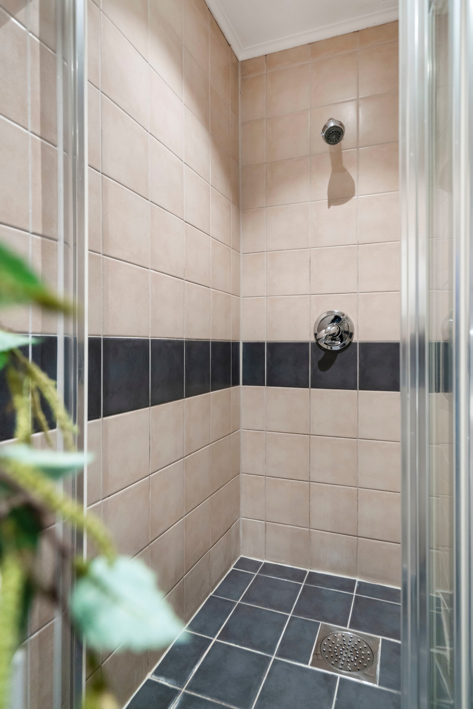 Fliser på gulv, fliser på vegger og malt himling. Dusjnisje med skyvedører og skjult rørsystem til dusjarmatur. Galleribilde