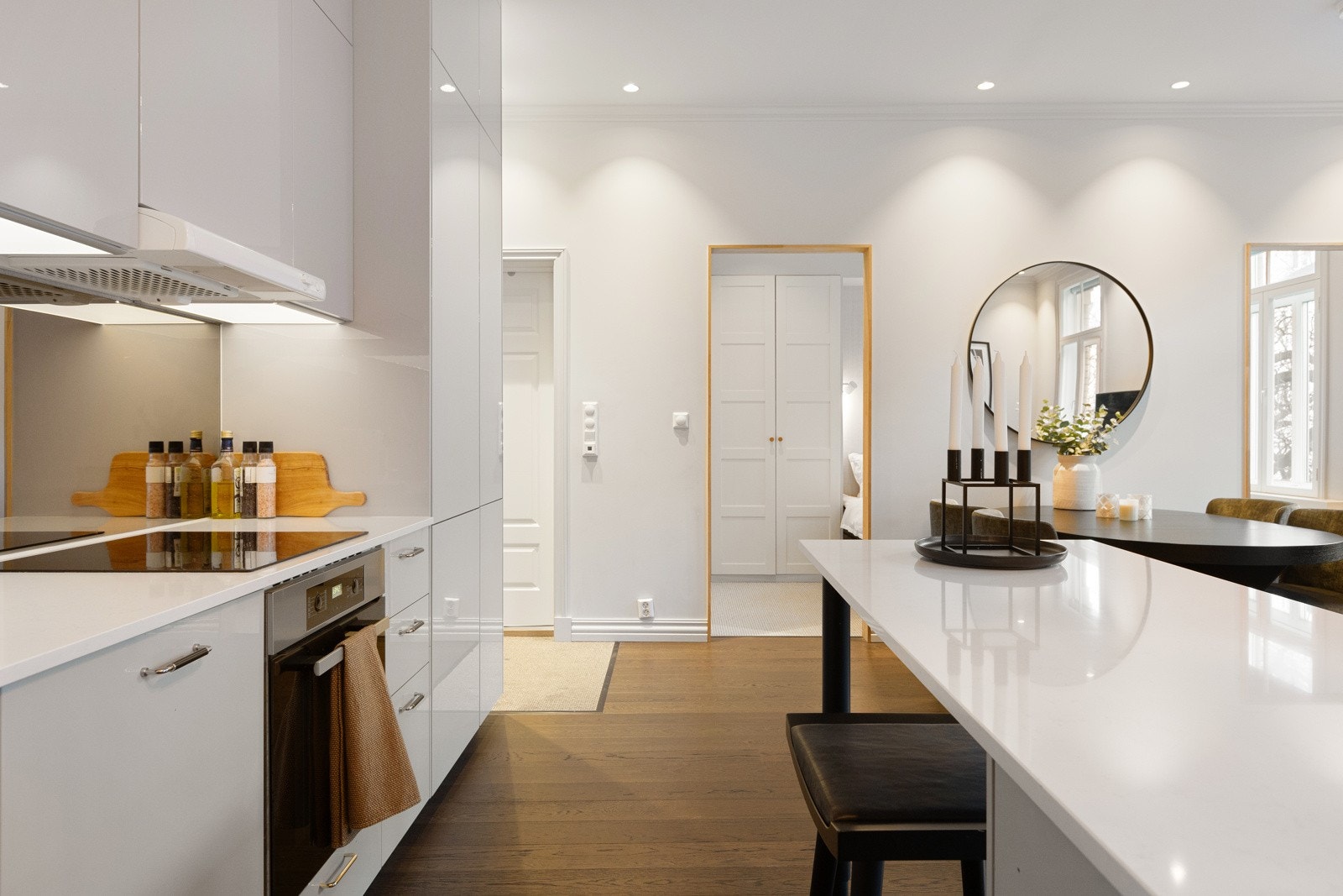 Kjøkkenet er innredet med integrerte hvitevarer som komfyr, induksjonstopp, oppvaskmaskin, kjøl og fryseskap Galleribilde