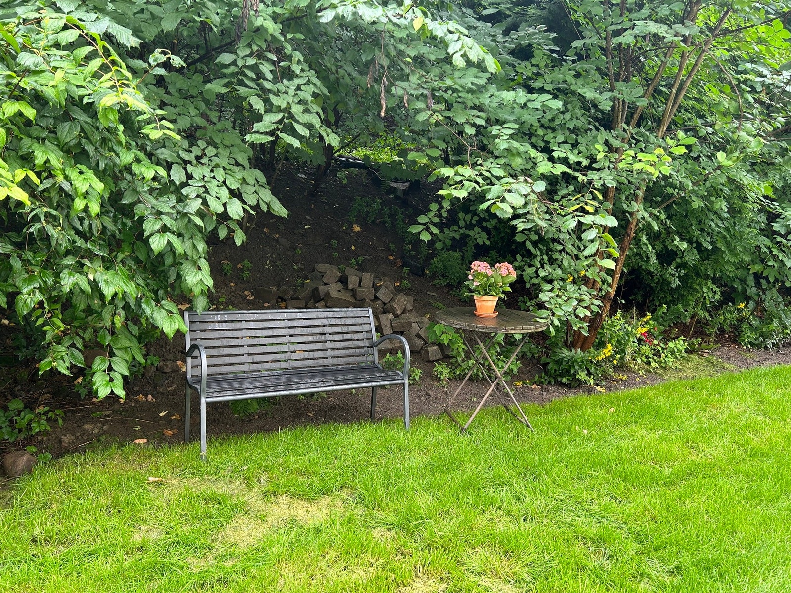 Bak leiligheten er det en hageflekk med utemøblement som har morgensol. Galleribilde