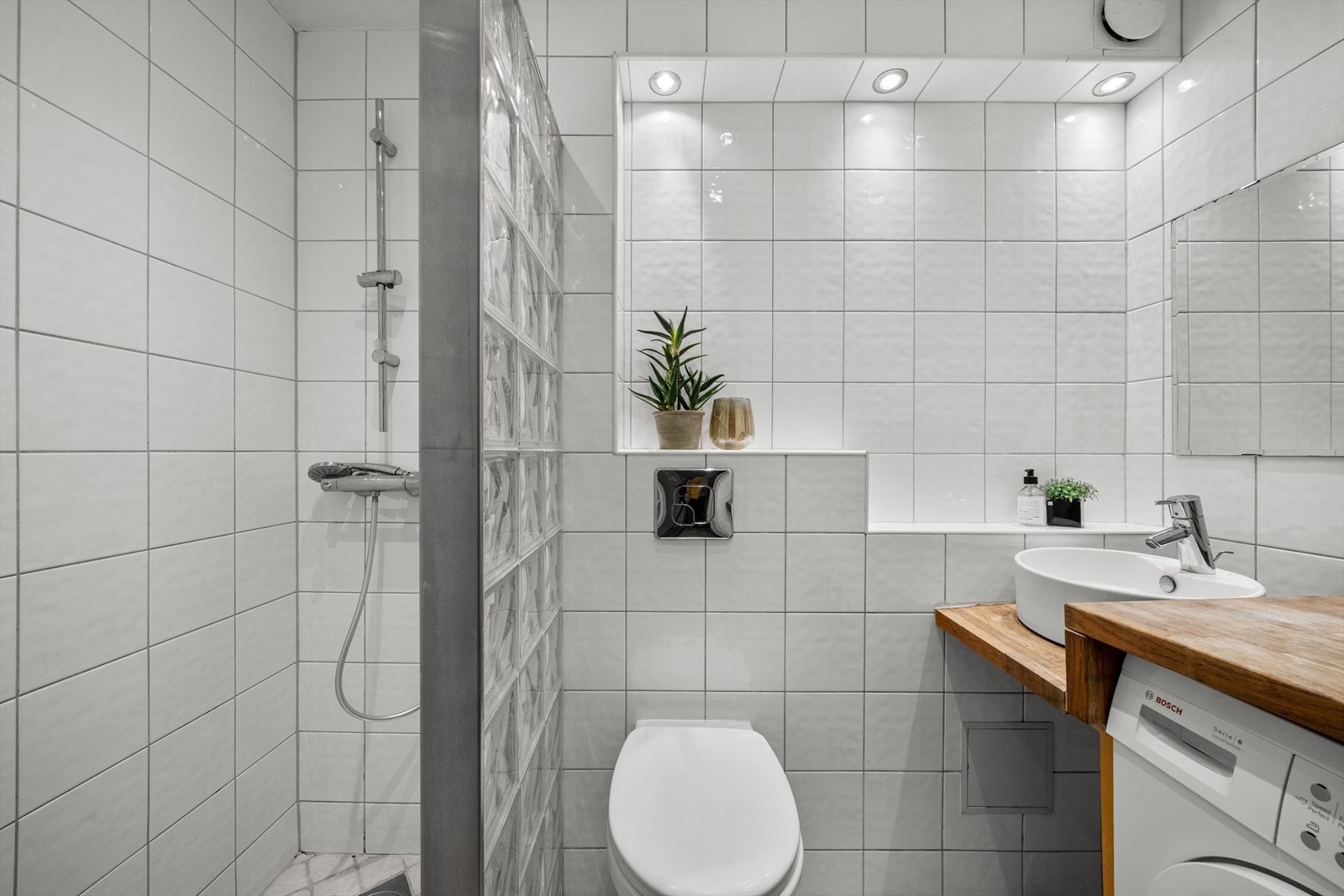 Lyst flislagt bad med downlights. I følge tidligere prospekt er badet fra 2009/10. Galleribilde