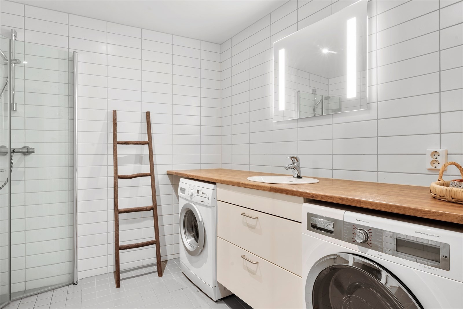 Moderne og pent bad med opplegg for både vaskemaskin og tørketrommel under benkeplate. Galleribilde