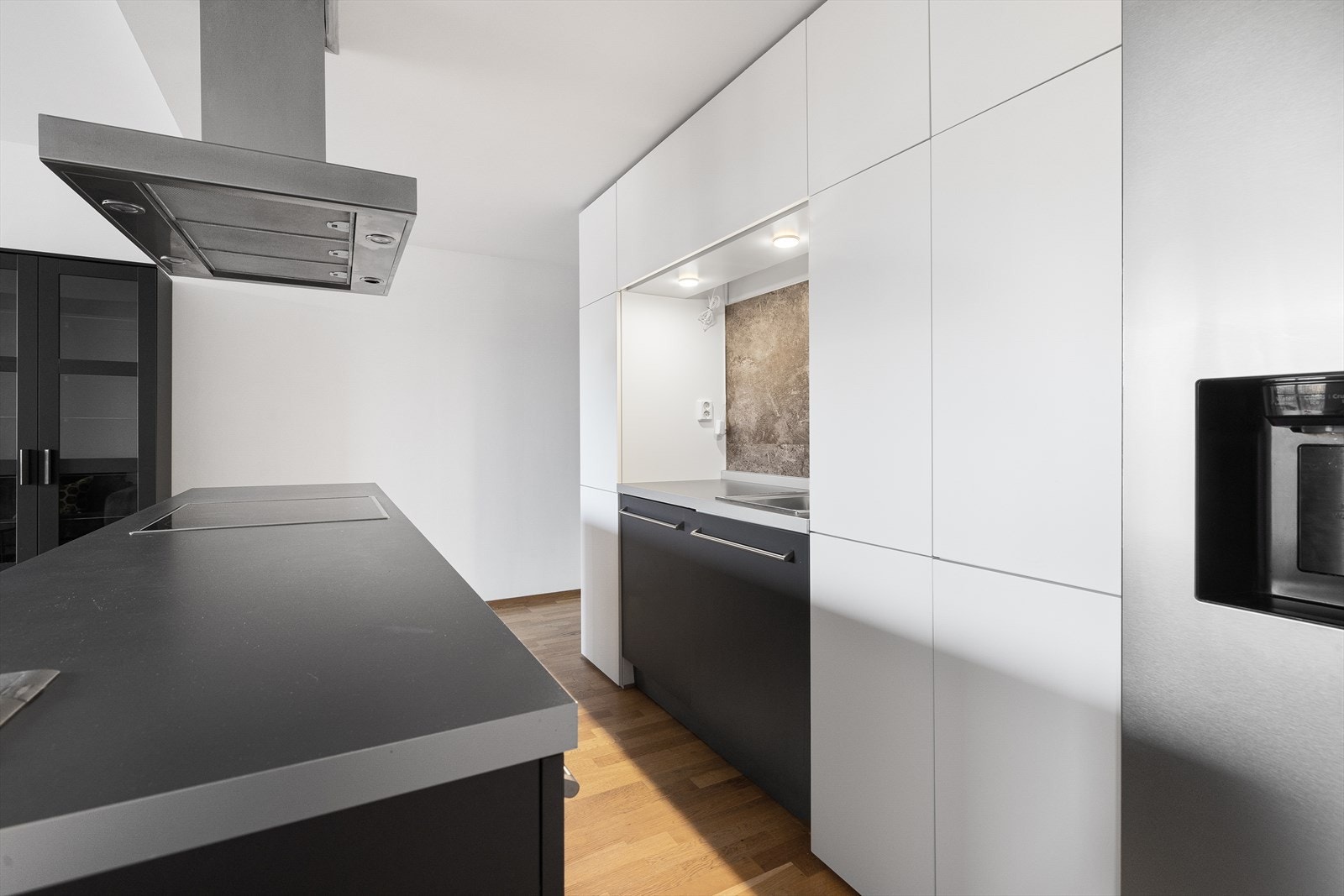 Stor kjøkkenøy med lagringsplass og integrerte hvitevarer. Galleribilde