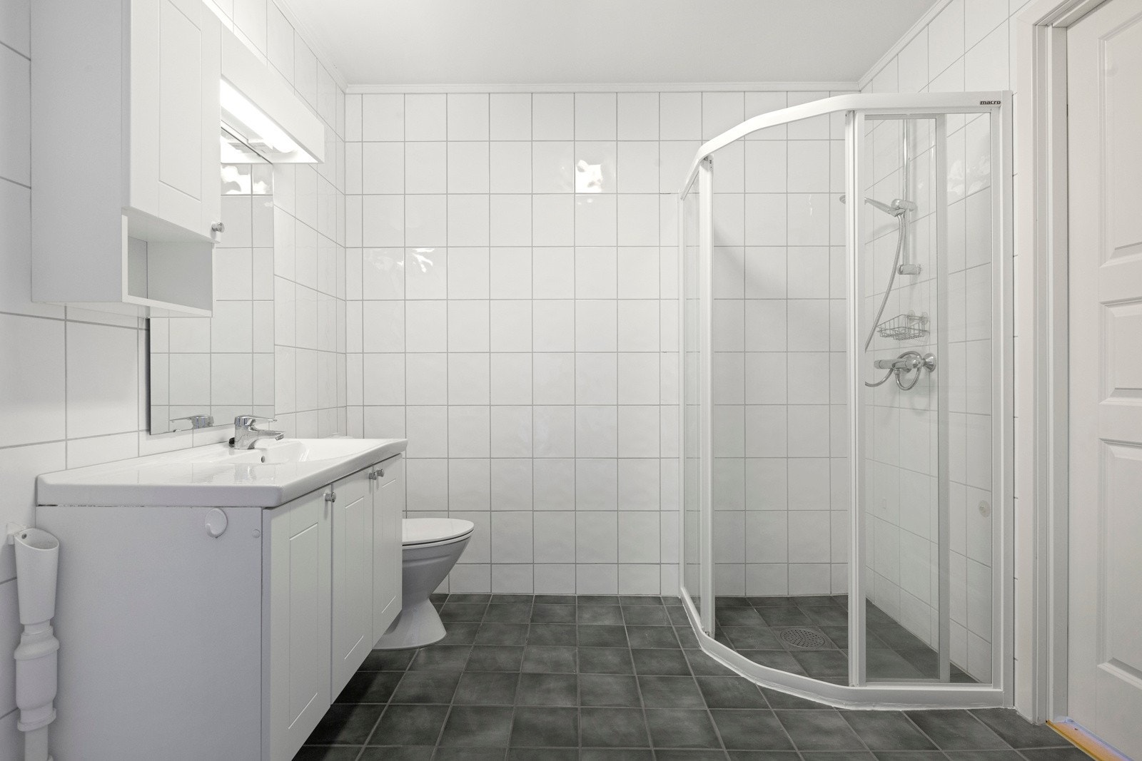 Badet har lyse fliser på gulv og vegger Galleribilde