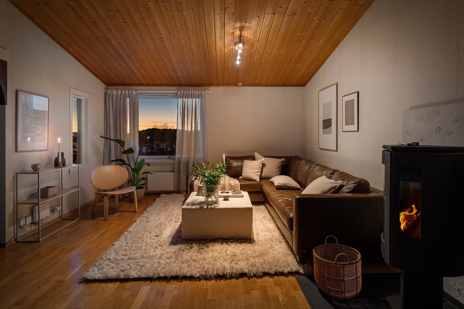 Koselig stue med peis, store vinduer og naturlig lys. Perfekt for avslapning i et fredelig hjemmemiljø. Galleribilde