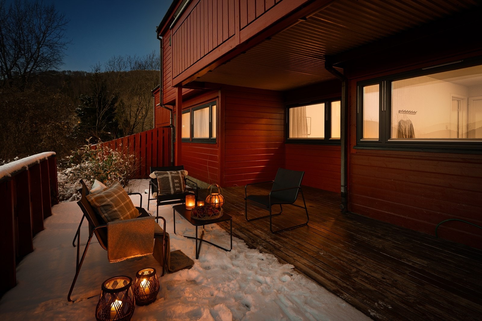 Koselig uteområde med snødekket terrasse og stemningsfulle lykter. Galleribilde